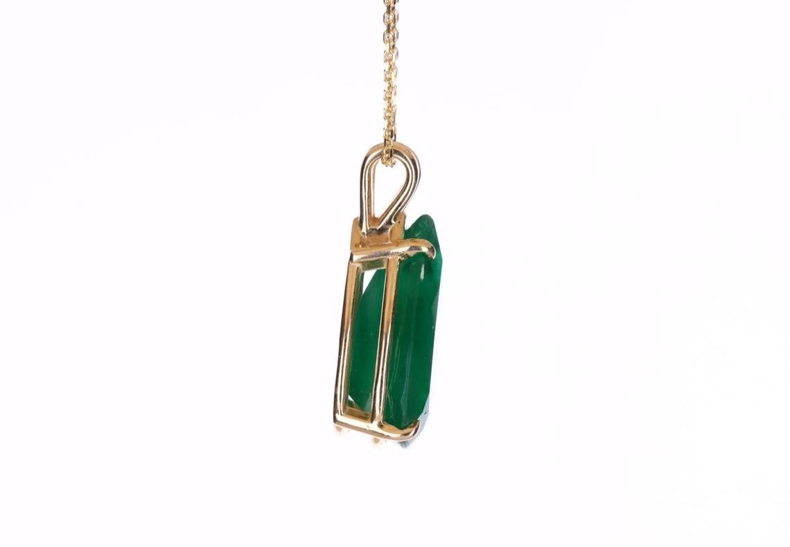 Featured here is a stunning, HUGE pear emerald pendant in fine solid 14k yellow gold. Displayed in the center is a rich dark green emerald set in a gold four-prong classic mount by our master goldsmith Robison. The earth mined, green emerald has a