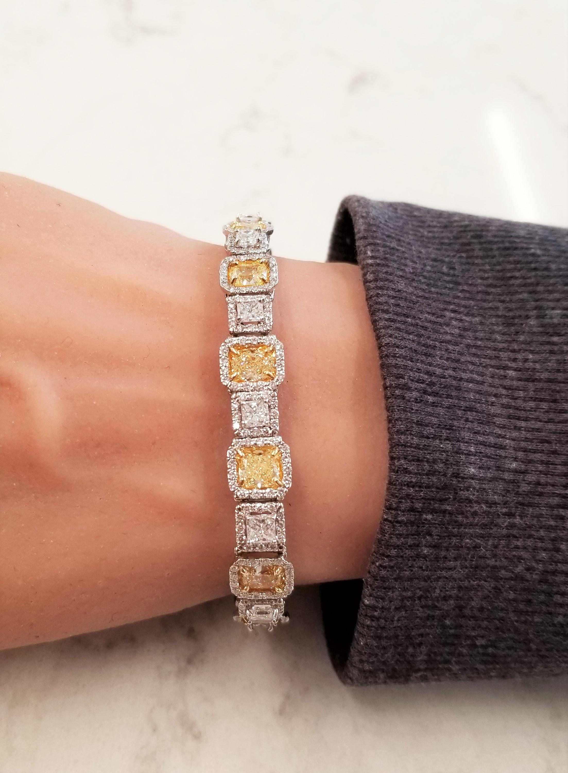 This bracelet is pure diamond luxury. 13 natural fancy yellow cushion cut diamonds weigh 10.5 carats and are paired with 13 stunning princess cut white diamonds totaling 3.55 carats. The construction of this bracelet is superb. The natural yellows