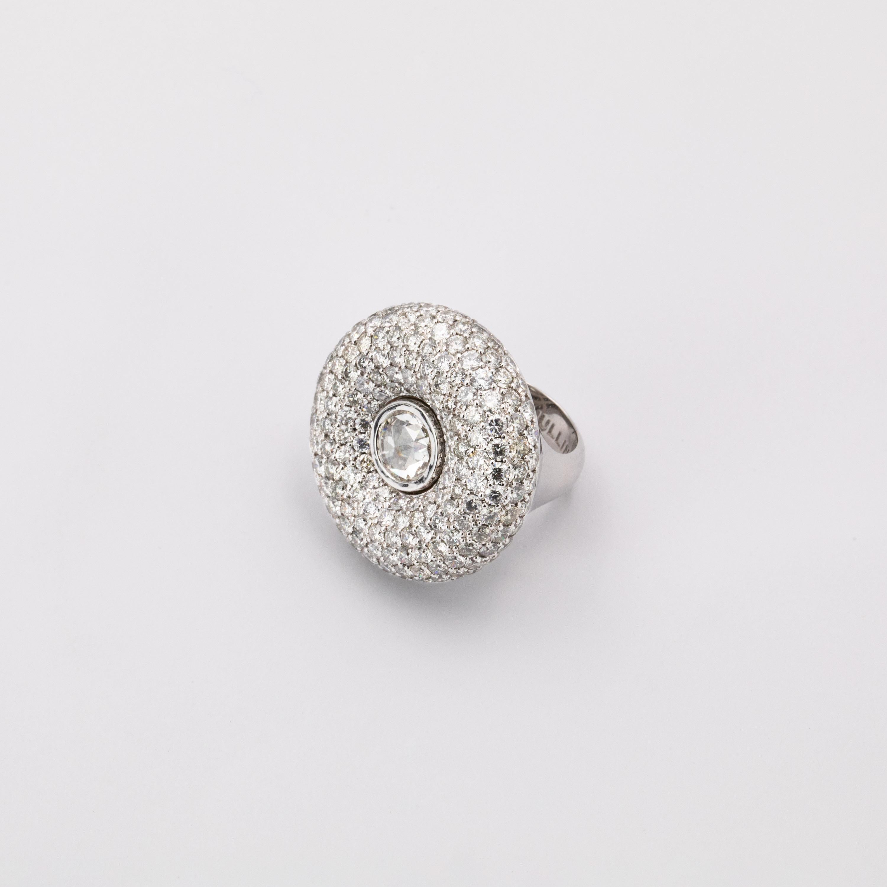The design of this ring features a voluminous halo of 7, gradually increasing then decreasing rows, set with 202 fancy grey diamonds weighing 10.07 carats, emphasizing the rounded shape. The centre of the voluptuous surface features a 1.64 carat
