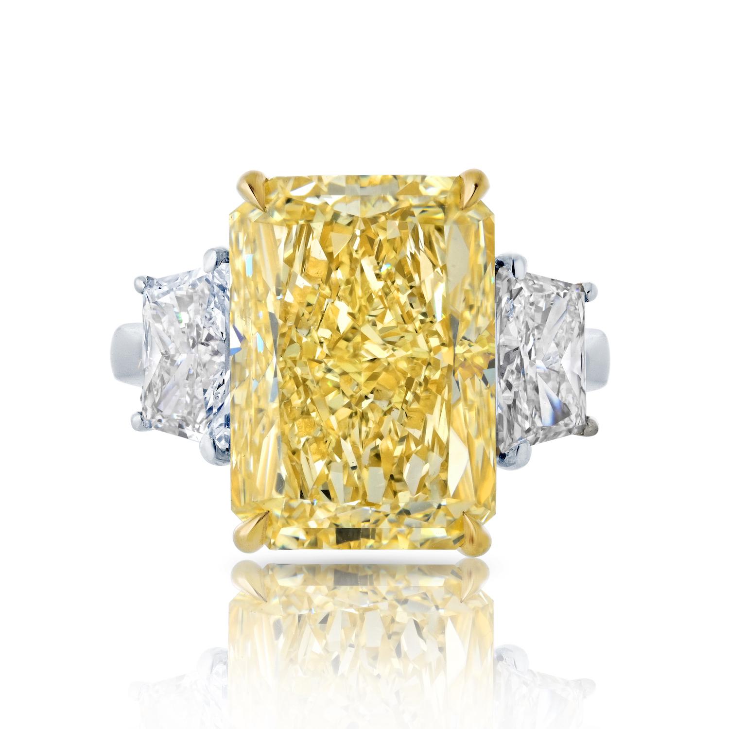 Don't miss the opportunity to make this extraordinary three stone diamond engagement ring yours. 

Featuring a breathtaking 10.07-carat radiant cut fancy yellow diamond, certified by GIA as VVS2 clarity, and brilliantly complemented by 1.57 carats