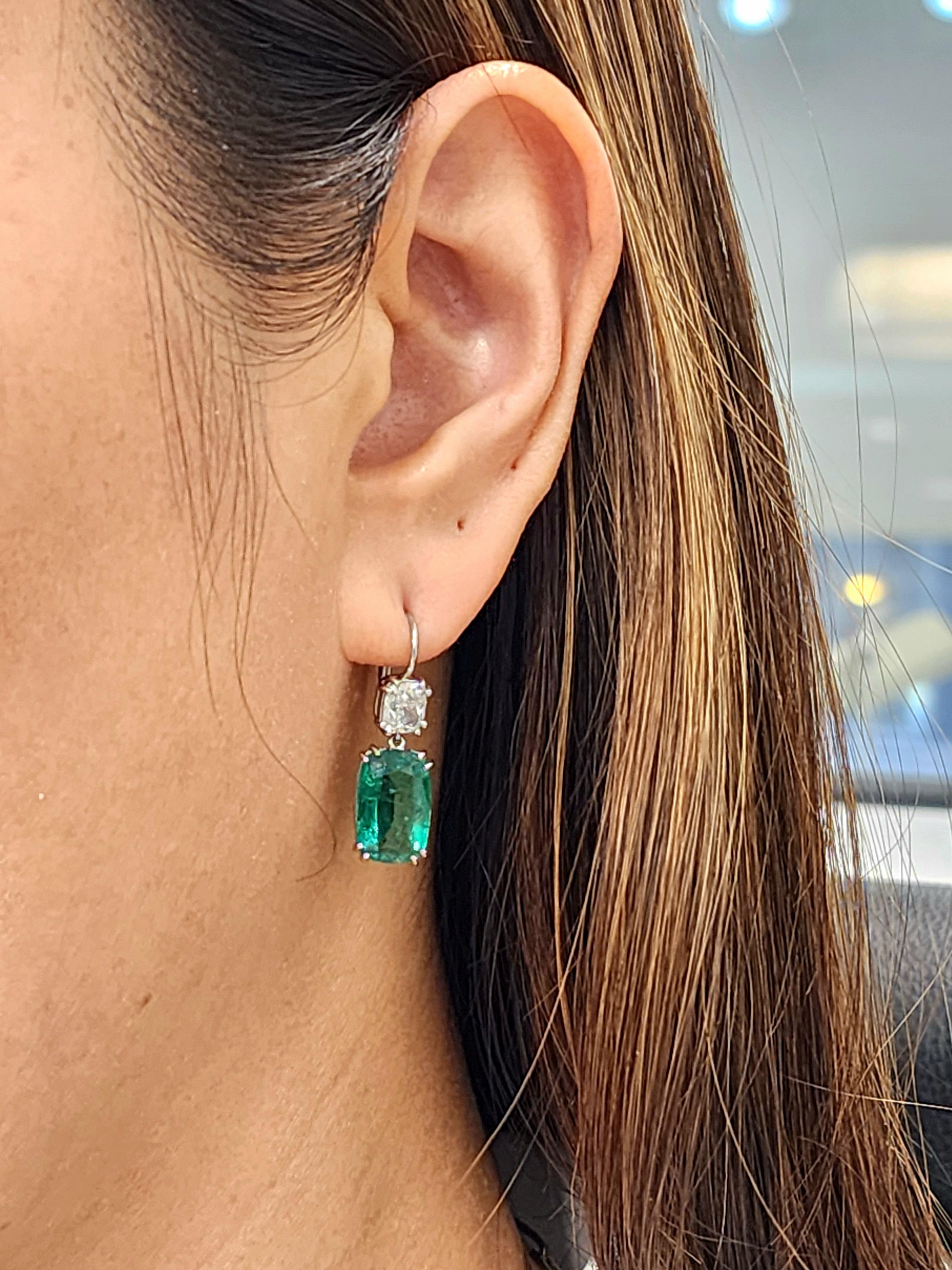 These exquisite drop earrings feature GIA-certified cushion-cut emeralds weighing 8.22 cts and GIA-certified cushion-cut diamonds weighing 1.86 cts. The emeralds display a vibrant green hue, while the diamonds are a pristine white, graded E/F in