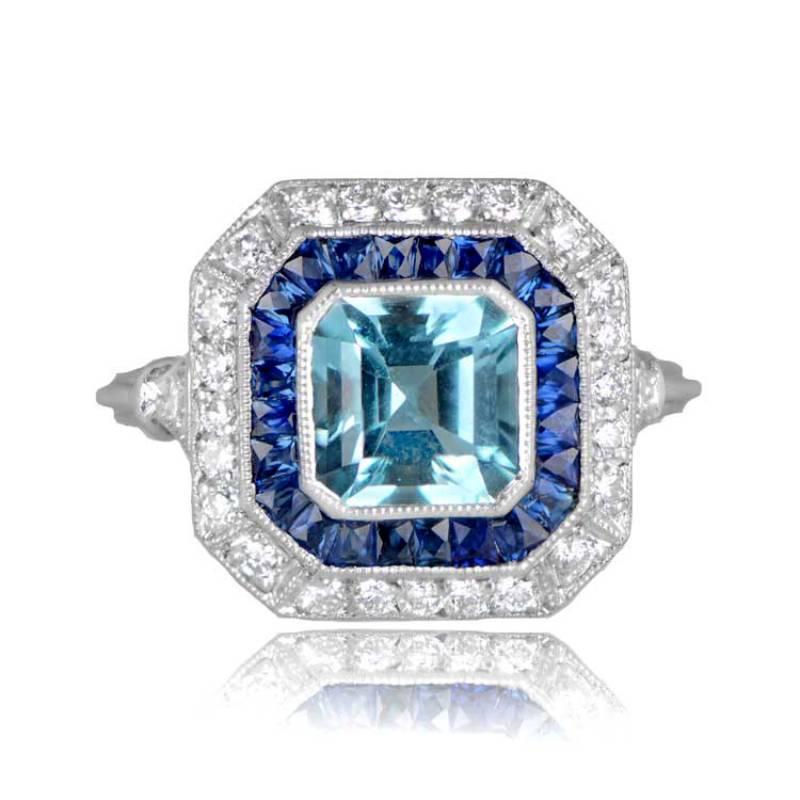 A double halo aquamarine ring that features an approximately 1-carat Asscher-cut natural aquamarine gemstone with a lively vivid teal color. The center gemstone is eye-clean and has no visible inclusions. Surrounding the center stone is a row of