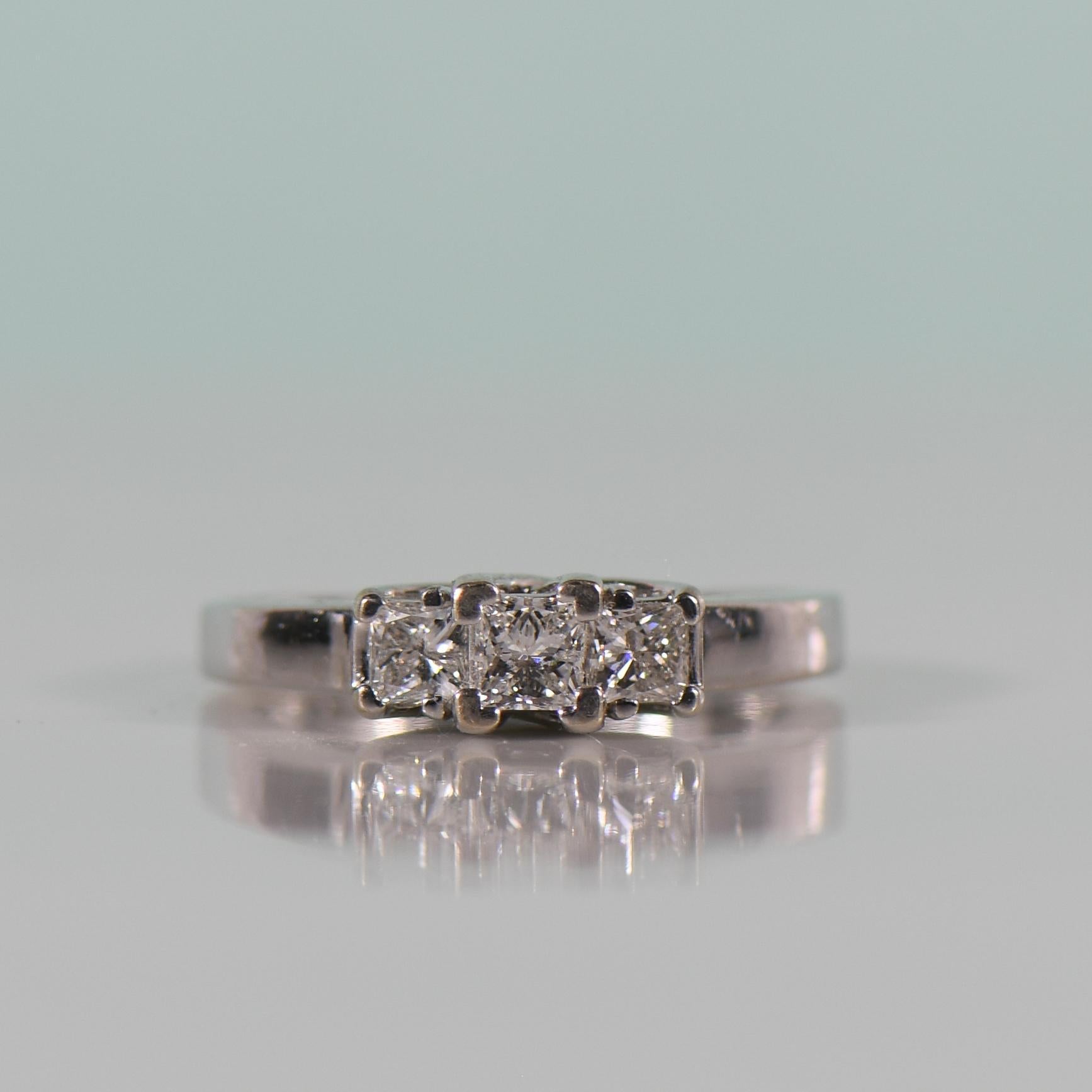 Elevate your love story with this modern masterpiece—a 1.00 carat, three-stone princess cut ring in a captivating trellis style setting. Designed to symbolize the past, present, and future of your relationship, each stone glistens with brilliance