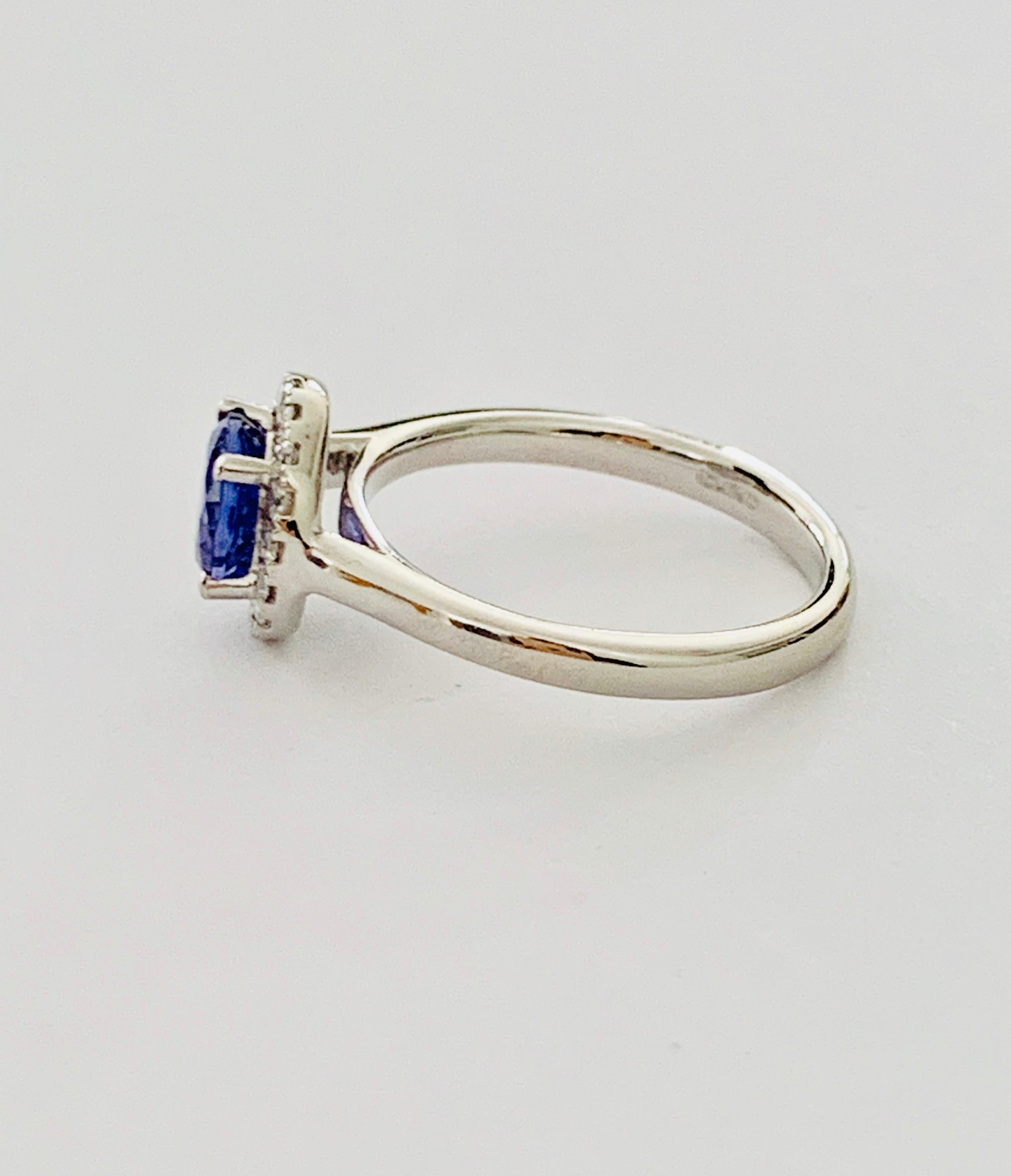 This very feminine and elegant round brilliant cut Tanzanite* is a medium blue colour with flashes of lilac.  It is set in a Platinum round diamond halo .  There are a total of .16ct of diamonds in the halo, these round brilliant cut diamonds are G