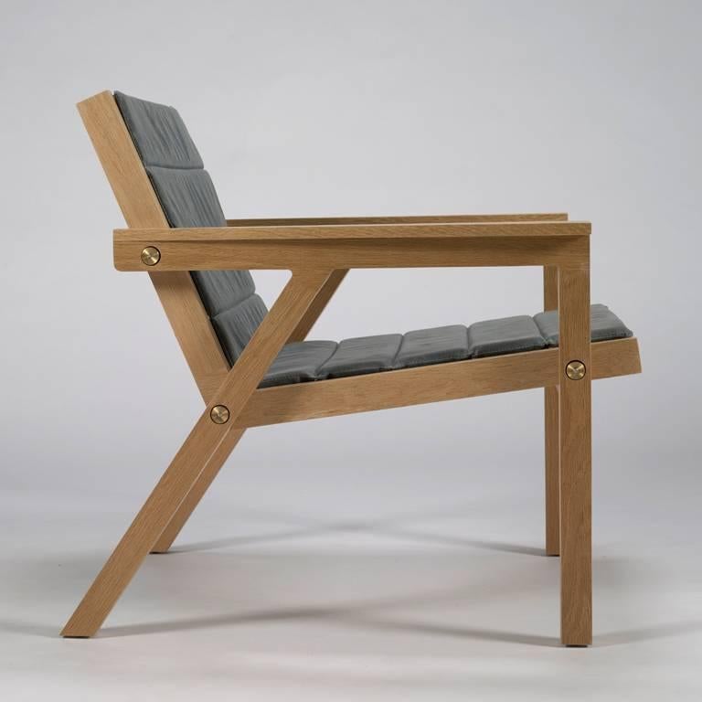 100xbtr contemporary breezeway chair in oak and waxed canvas. Two side profiles are held together with brass rods and custom hardware - a thin pad waxed canvas.