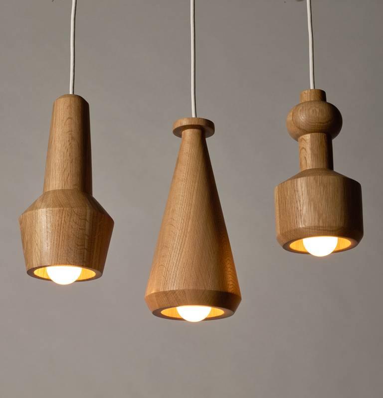 Set of three solid oak bottle pendant hanging lights. Hand-turned pendants which make for excellent accent lighting when illuminated and unique hanging sculptures when they are turned off.

The lampss are inspired by scientific lab equipment and