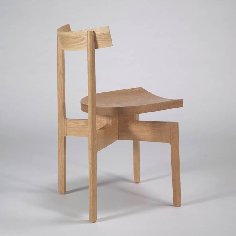 An elevated dining chair with an architectural form in solid white oak. The stoolback is wonderfully versatile and stacks for a smaller footprint when not in use.