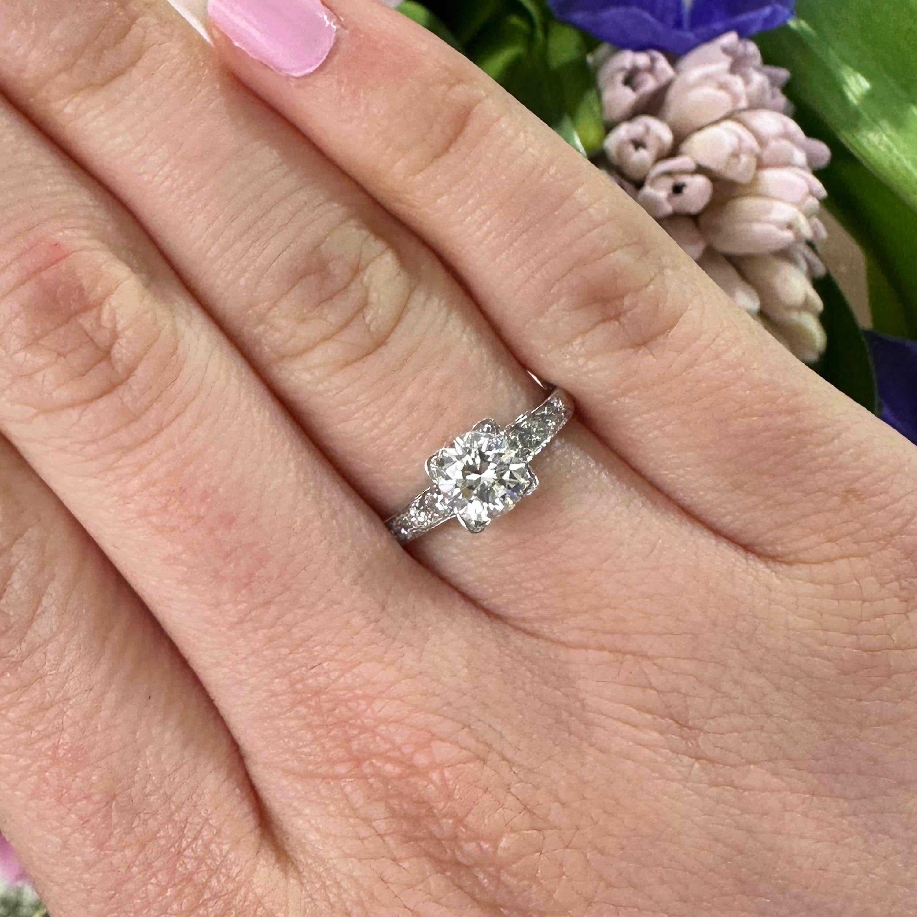An American vintage diamond ring, set with a round brilliant cut diamond, weighing 1.01ct, G colour, VVS2 clarity, with three eight-cut diamonds set in each shoulder, mounted in platinum.

Finger size UK L ½ / US 5 7/8.