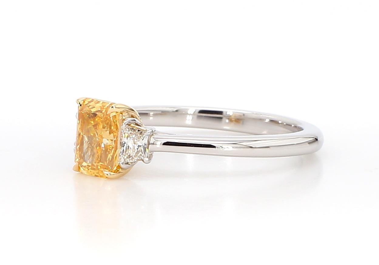 Ce diamant fantaisie jaune orange intense à trois pierres, rehaussé de deux trapèzes blancs de part et d'autre, témoigne de la finesse de l'artisanat et d'un design intemporel. Parfaite pour ceux qui apprécient la beauté des diamants naturels rares