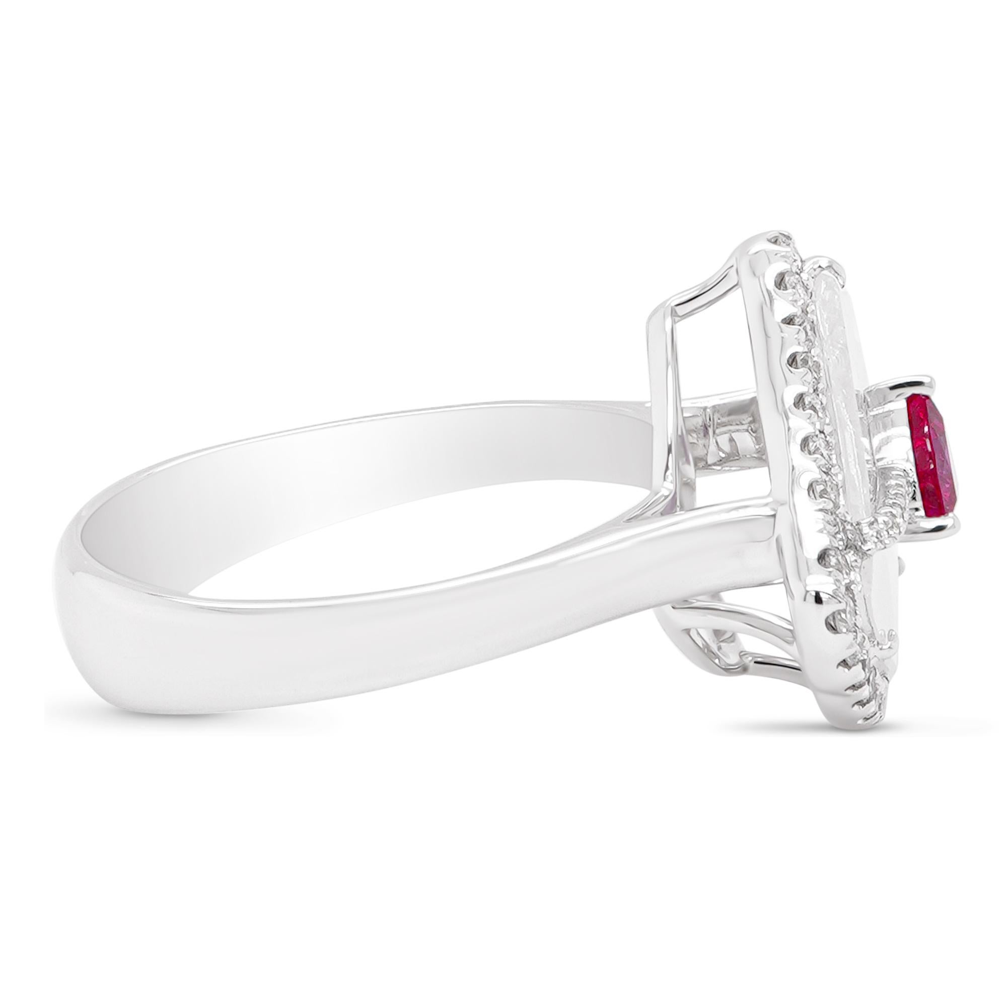 Crimson red ruby weighing 0.28 carats is sitting on top of a 1.01 carat Glacier color diamond as a crown in this designer 18K ring. A total of 0.27 carats of white round brilliant diamonds are set as well. The details of the diamond are mentioned
