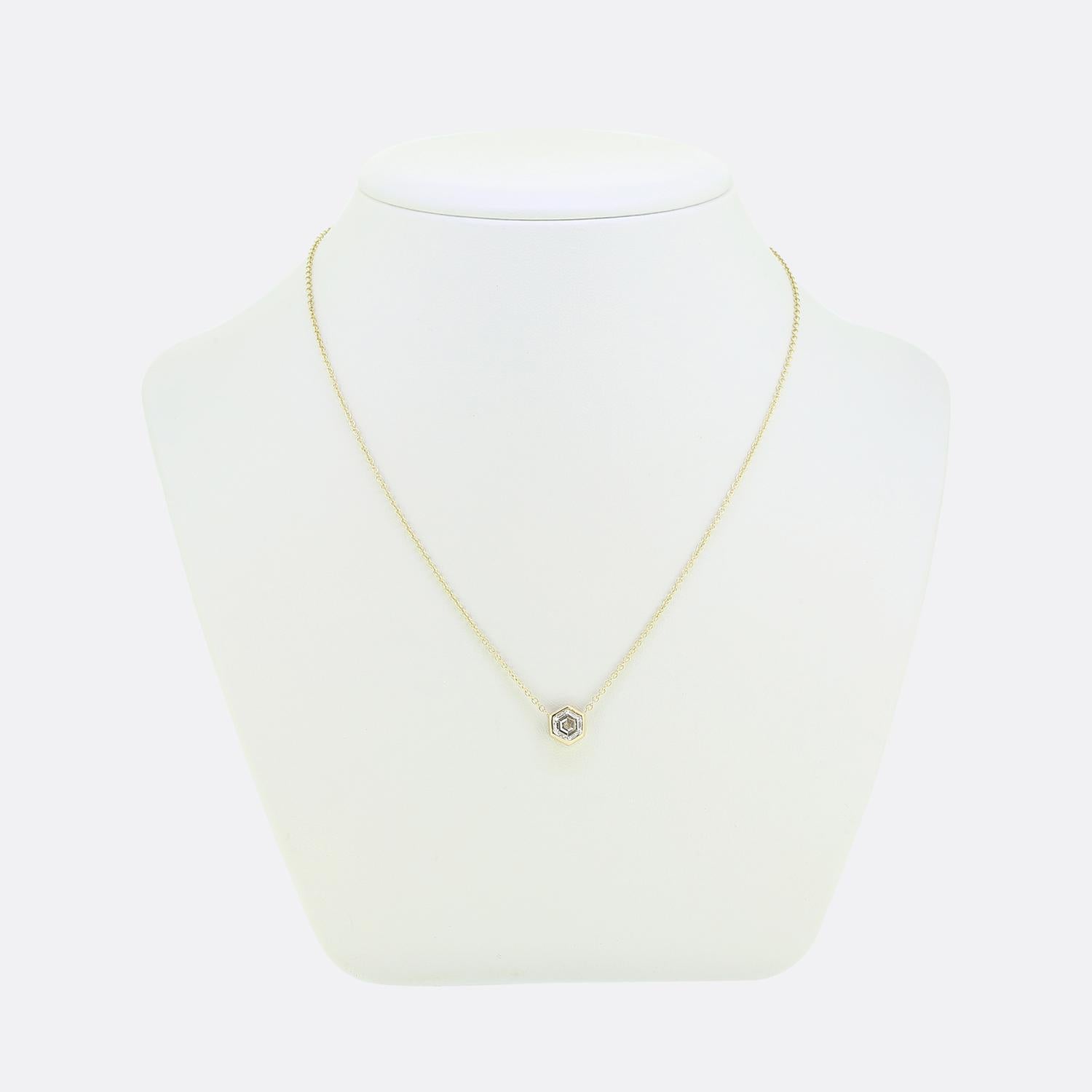 Voici un collier raffiné en or jaune 18ct. Cette pièce présente un captivant diamant blanc brillant taillé en hexagone, soigneusement serti dans une monture hexagonale en or. Le design minimaliste permet au diamant d'occuper le devant de la scène