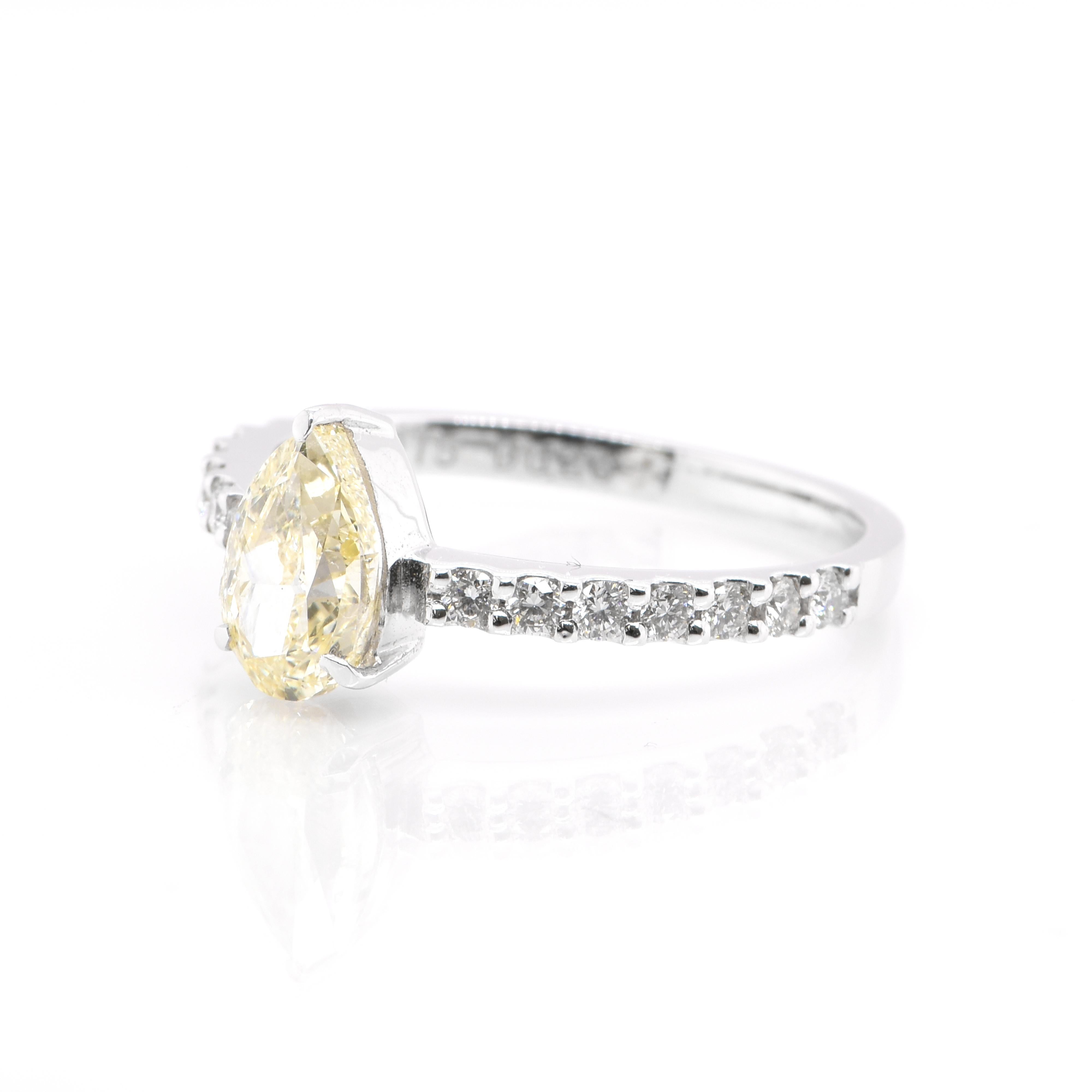 An elegant Chuo Gem Laboratory (Japan) Certified 1.01 Carat, Natural, Pear-Shape, Light Yellow, SI-1 Diamond in Solitaire Setting accompanied by 0.26 Carats of White Round Brilliant Diamond Accents. Set in Platinum. Diamonds have been adorned and