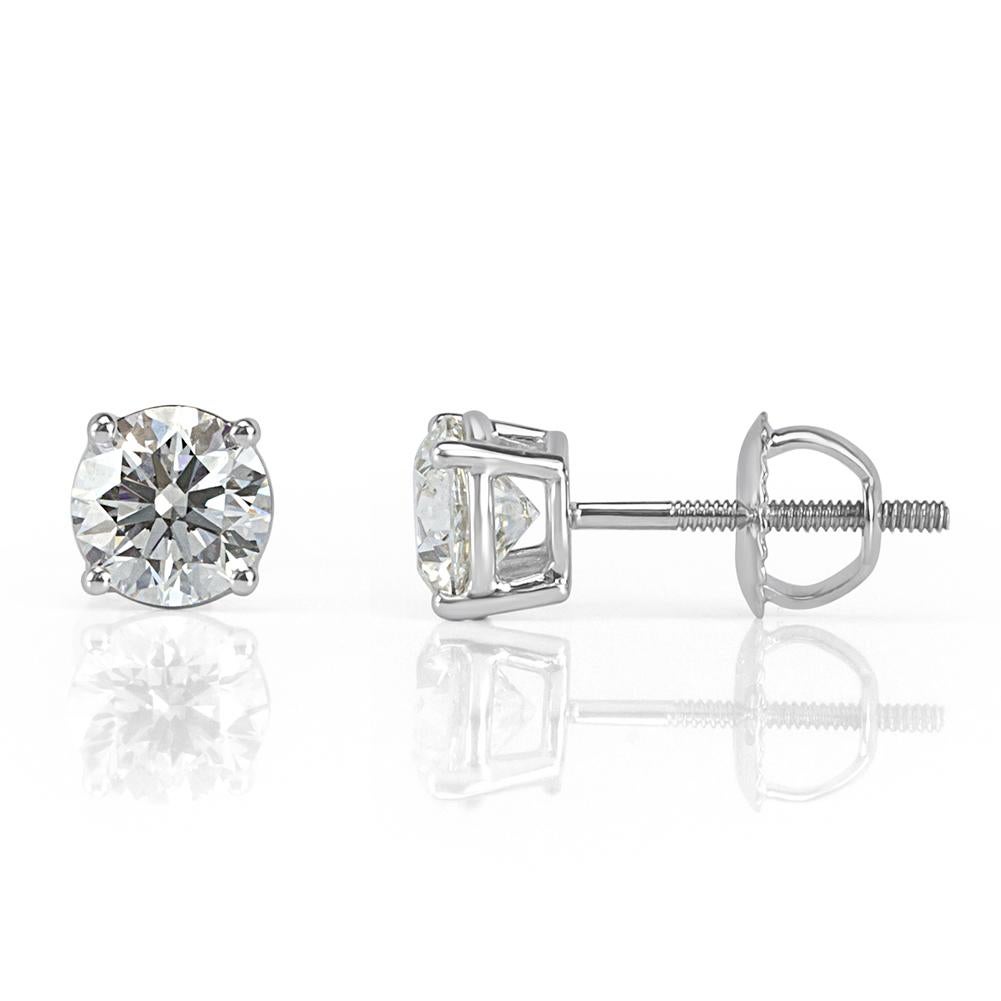 Handcrafted in 18k white gold, this beautiful pair of diamond stud earrings showcases two round brilliant cut diamonds with a total weight of 1.01ct, GIA certified at G-VS1 and G-VS2. They are set in a classic, four-prong setting style with screw