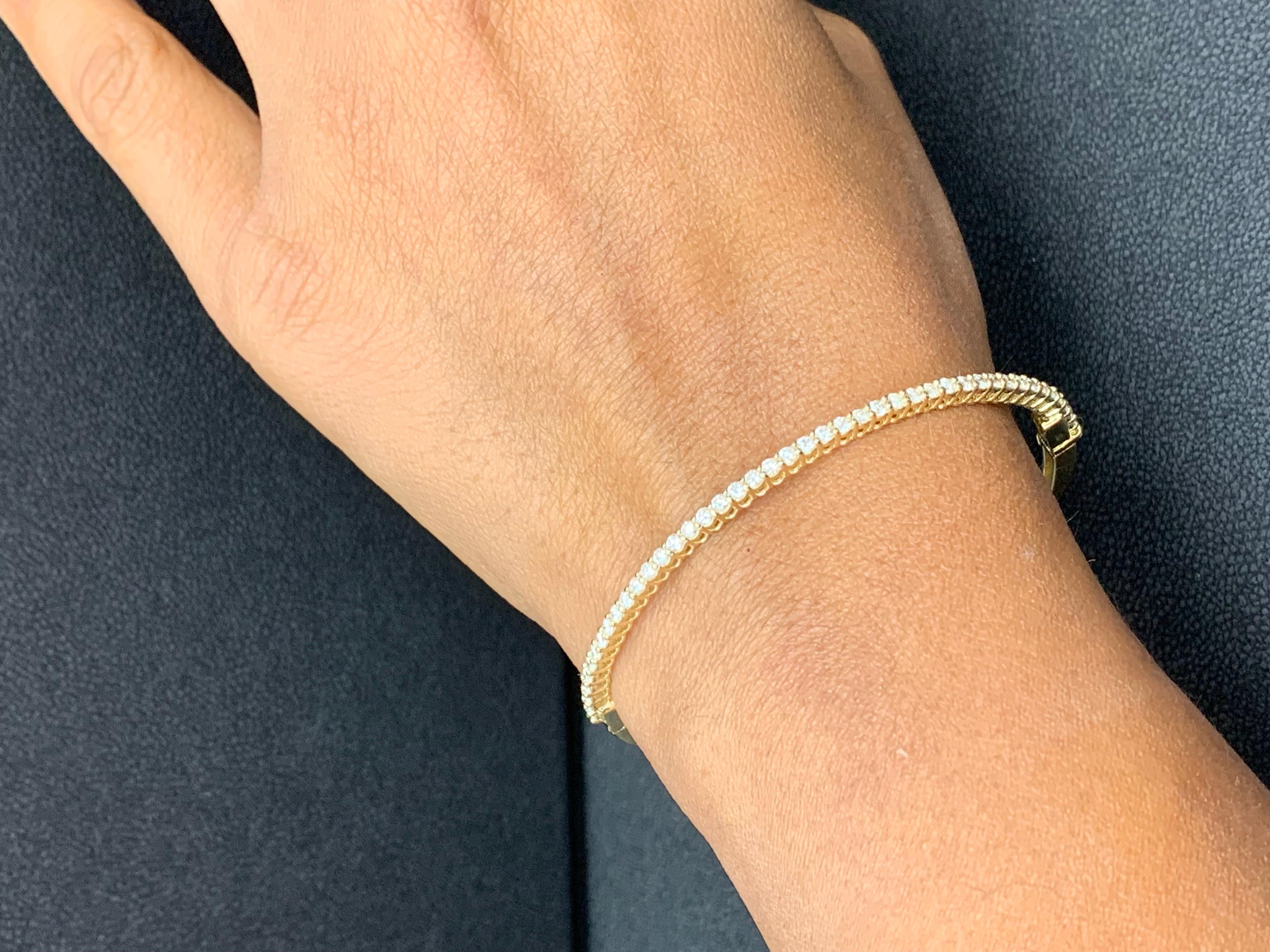 A simple but elegant bangle bracelet set with 39 round-cut diamonds weighing 1.01 carats total. Has a clasp to slip and wear the bangle securely. Made in 14k Yellow Gold.

Style available in different price ranges. Prices are based on your selection