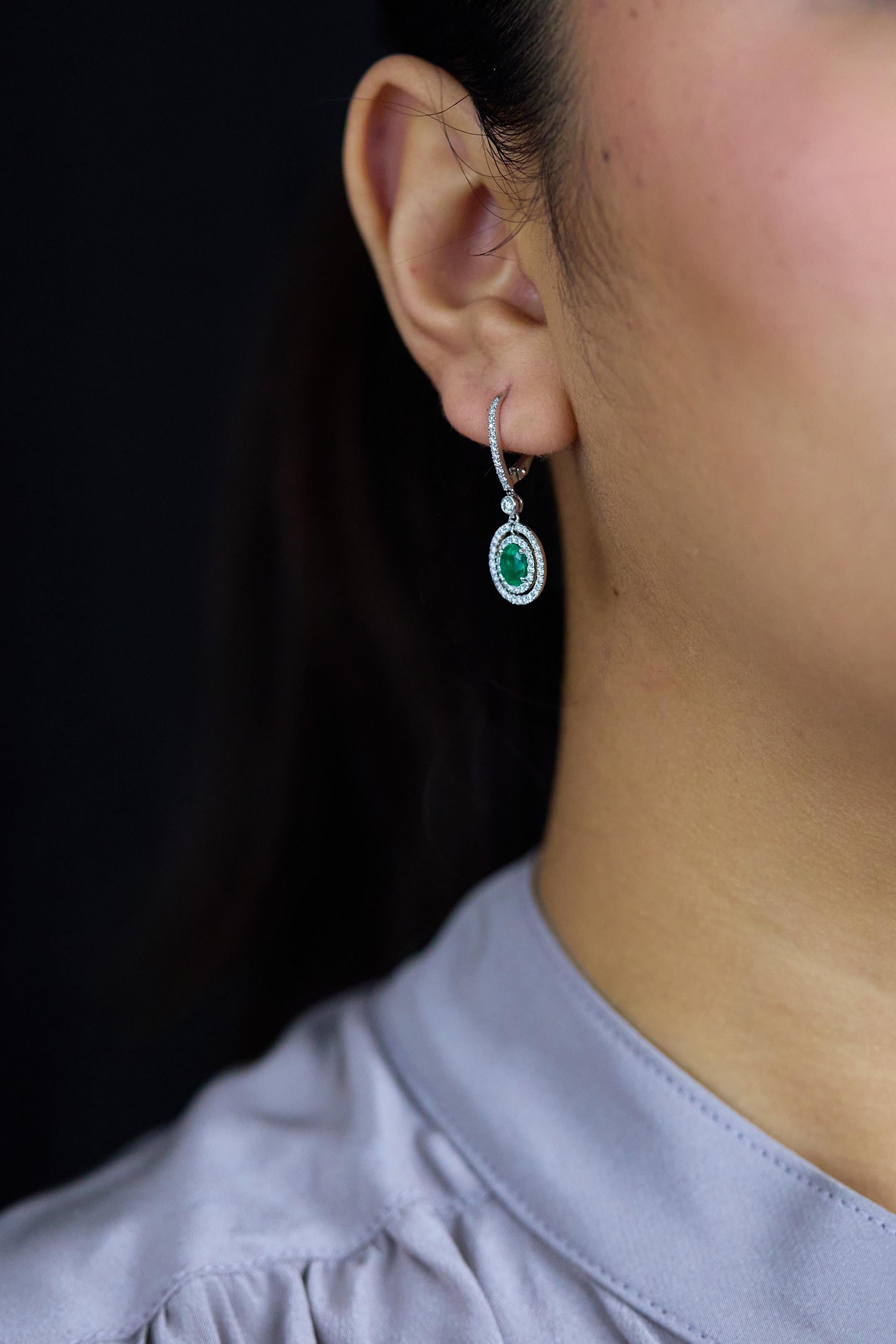 Modern 1.01 Carats Total Oval Cut Emerald and Diamond Halo Dangle Earrings For Sale