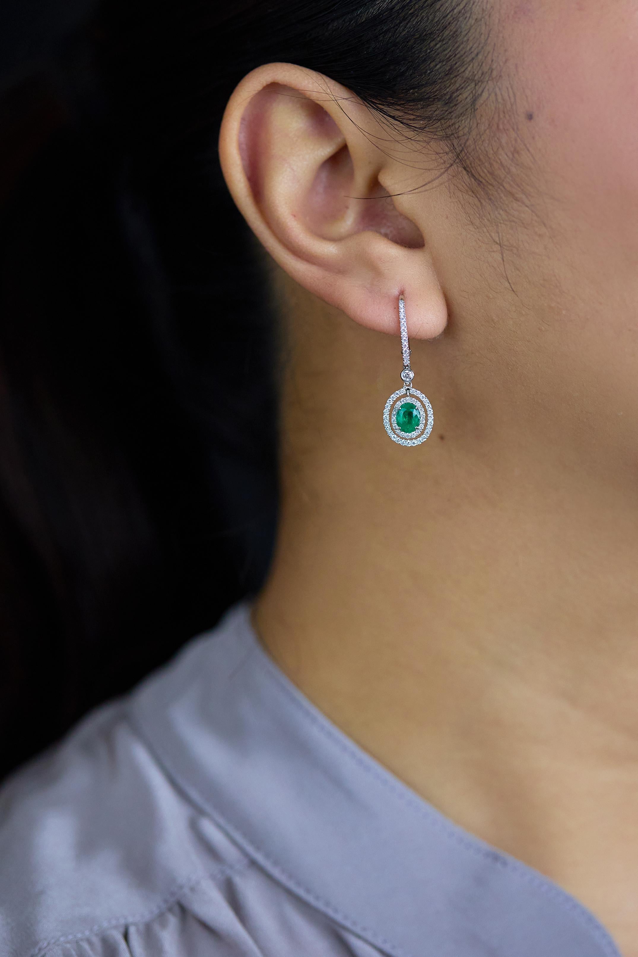 Women's 1.01 Carats Total Oval Cut Emerald and Diamond Halo Dangle Earrings For Sale