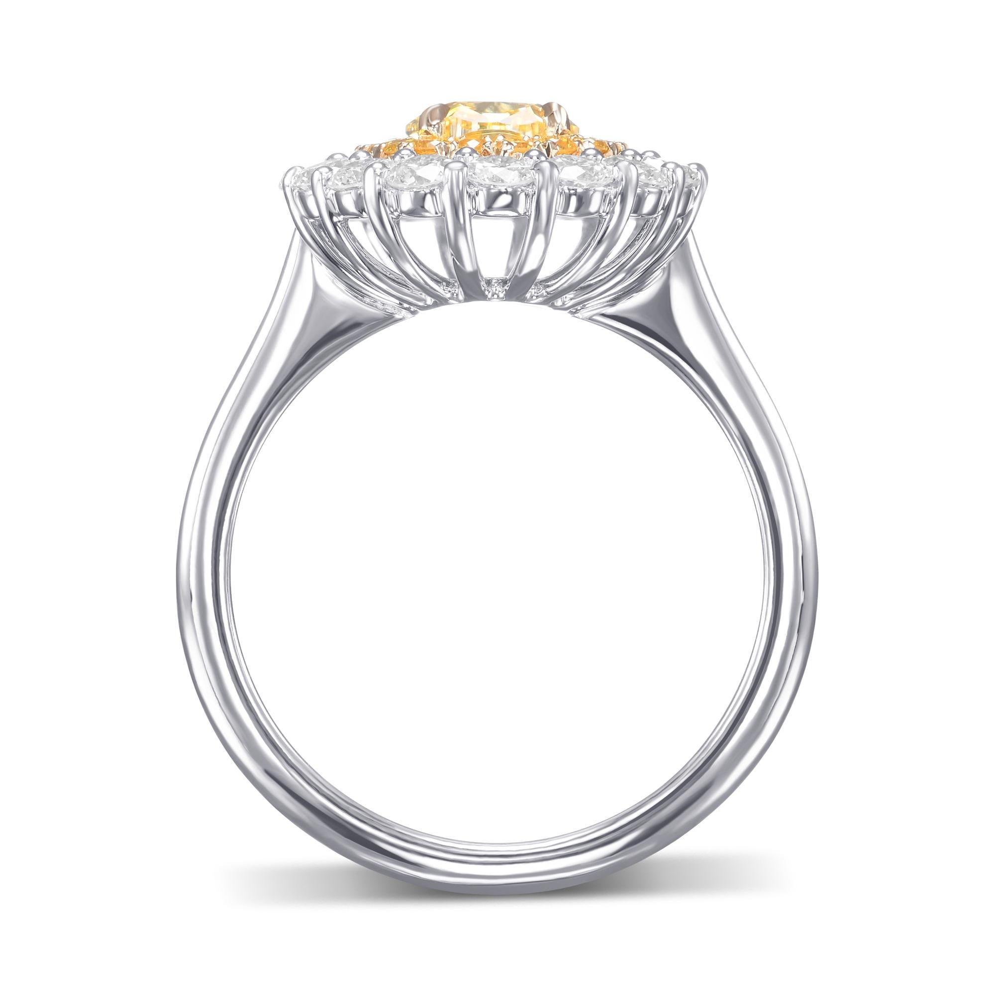 Un favoloso anello con doppio diamante aureolato ovale di colore giallo intenso, con una pietra centrale del peso di 1,01cts e certificato da GIA. L'anello presenta una doppia aureola bicolore con pavé aperto ed è montato in oro bianco e giallo 18