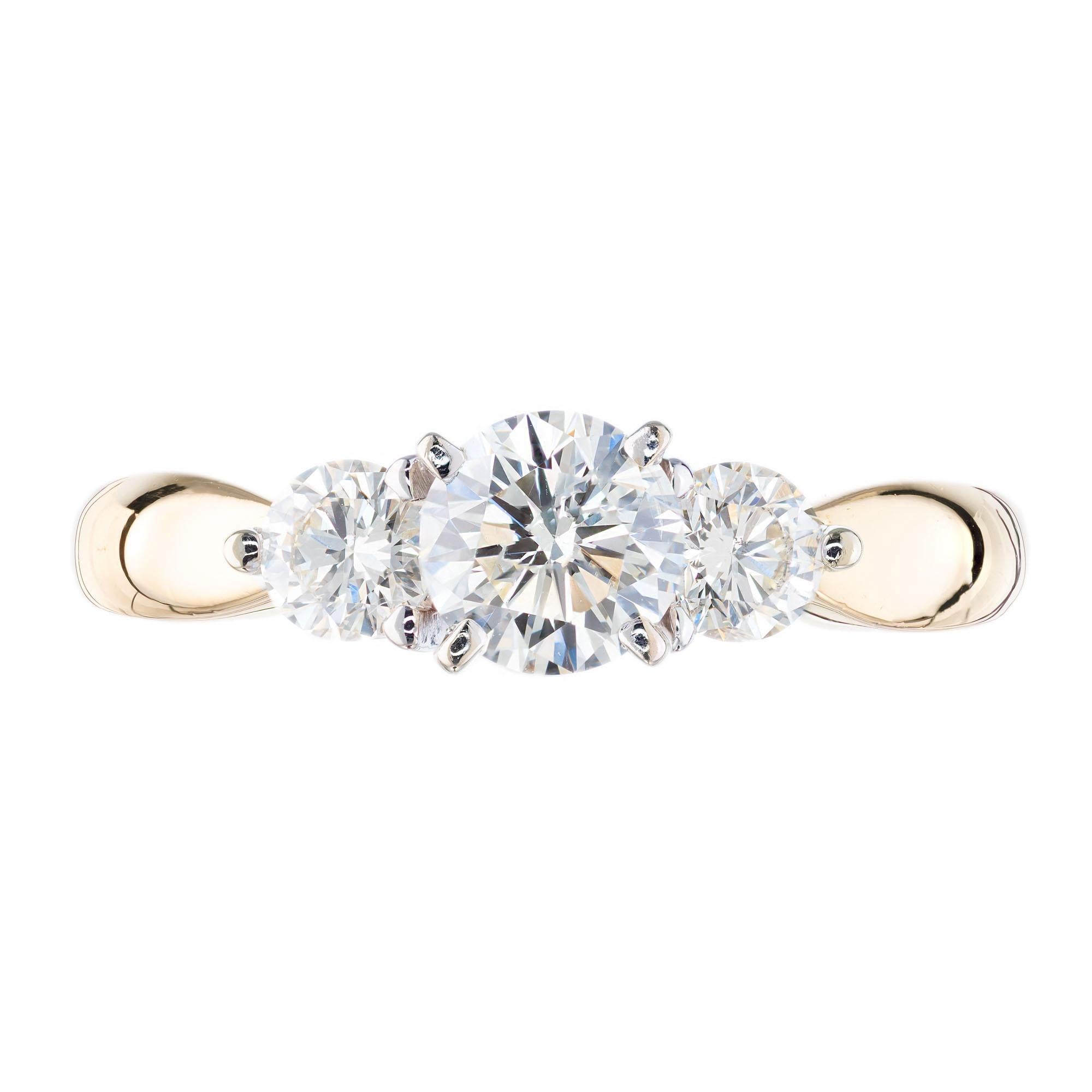 Three-stone diamond engagement ring. 3 round diamonds set in a 14k yellow and white gold setting. Yellow gold band with a white gold crown. 

1 round diamond .66cts
2 round diamonds approx. total weight .35cts
diamond's range: G-H color. VS2 –