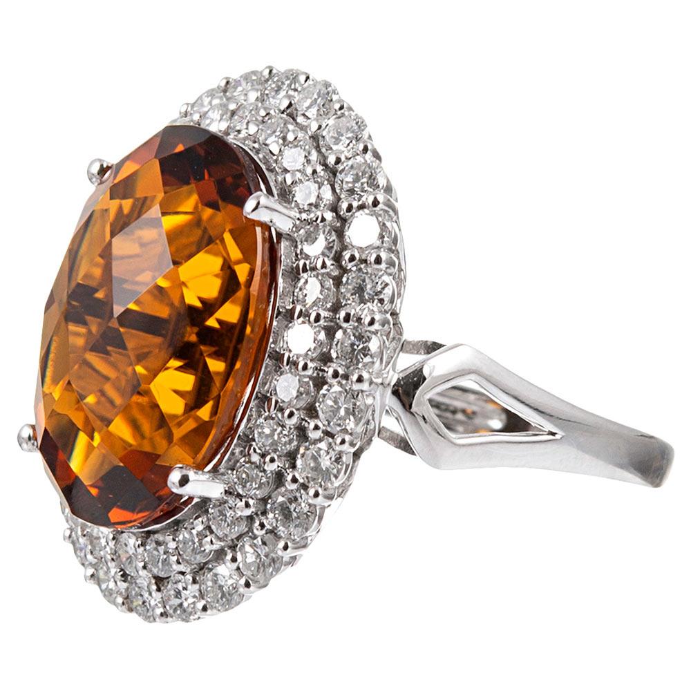 A double row of brilliant diamonds frames a checkerboard top citrine, allowing the stone’s alluring color to burst forth from the brilliant backdrop of the halo. The center stone weighs an impressive, yet wearable 10.13 carats, while the accent