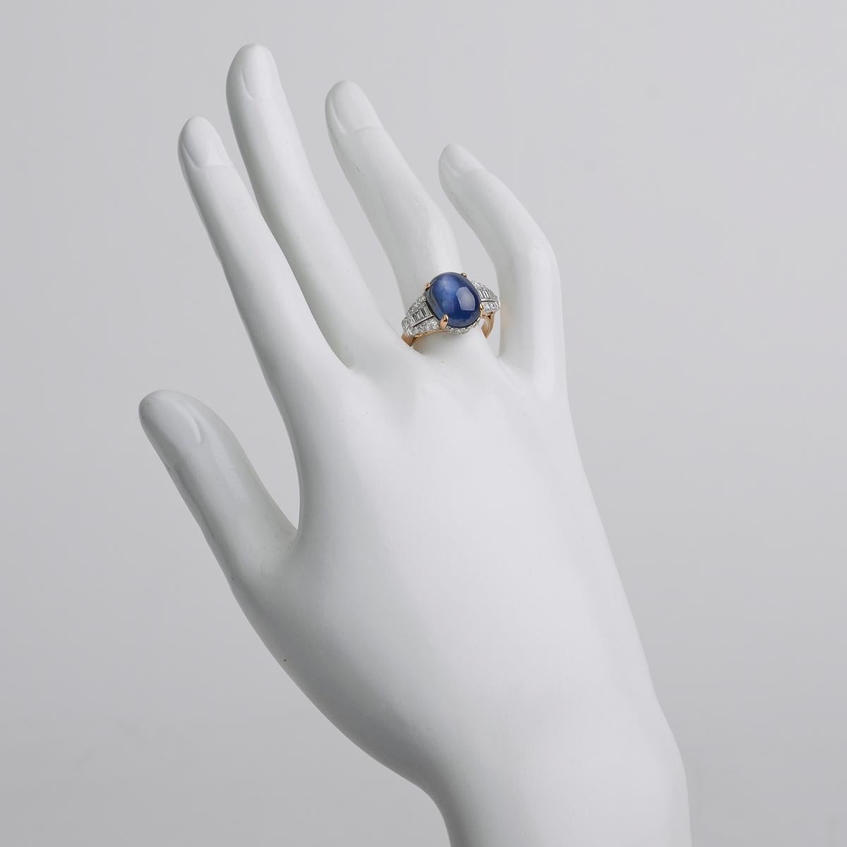 Dress ring, centering a fine cabochon-cut natural Burmese star sapphire weighing 10.18 carats, framed by baguette-cut and round-cut diamonds together weighing approximately 1.20 total carats, mounted in platinum and 18k yellow gold.