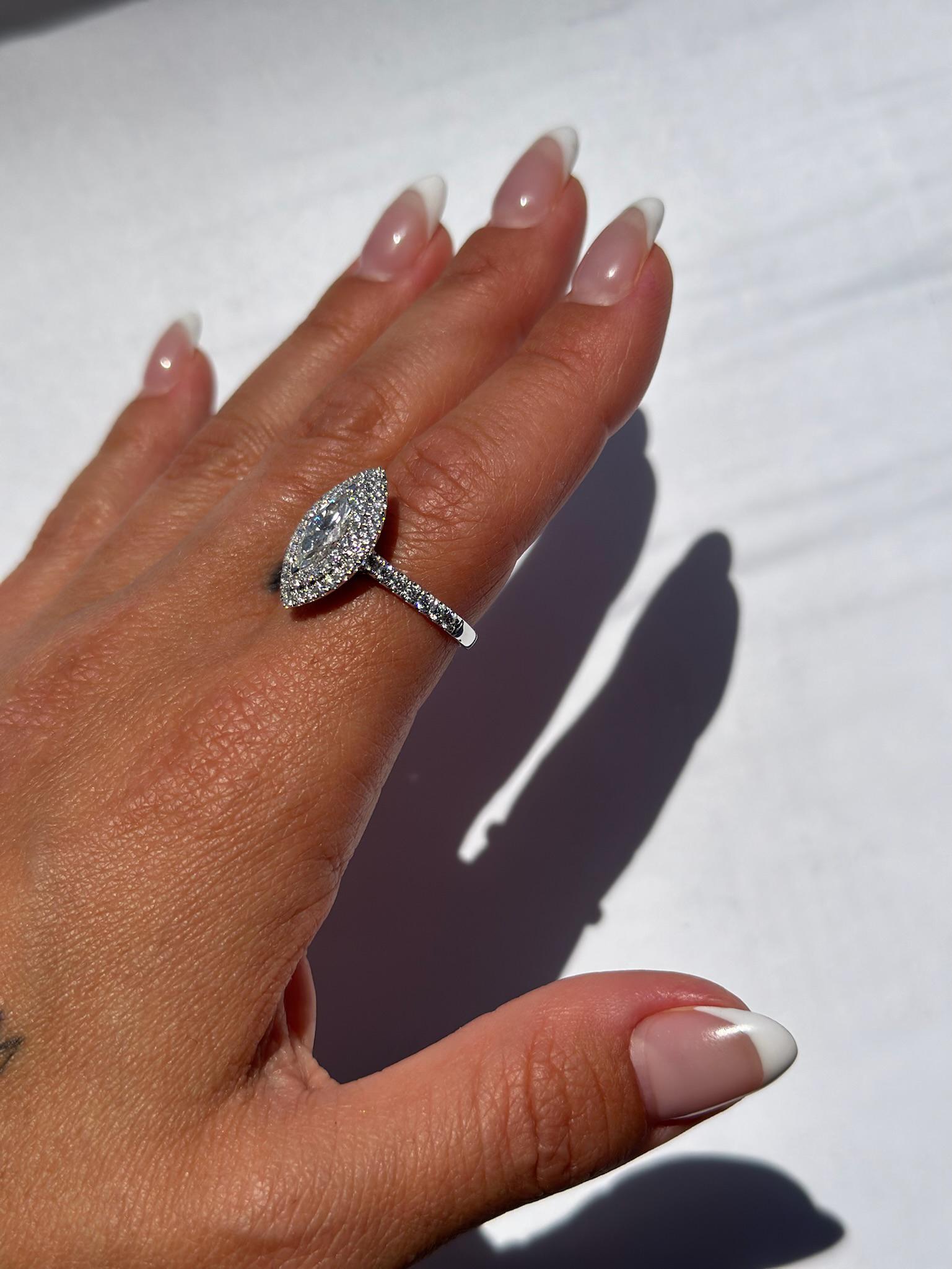 Voici notre exquise bague à double halo de diamants taillés en marquis de 1,01ct, un chef-d'œuvre à couper le souffle qui rayonne d'élégance et capture l'essence de la beauté intemporelle. 

La pièce maîtresse de cette remarquable bague est un