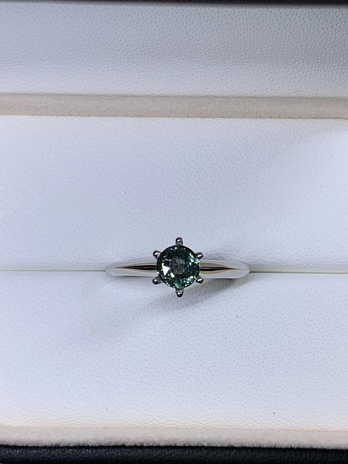 This exquisite ring is the perfect choice for a special occasion, like an engagement. Crafted from 18ct white gold and featuring a stunning round teal sapphire, it is a timeless piece of fine jewellery that will be treasured for years to come. The