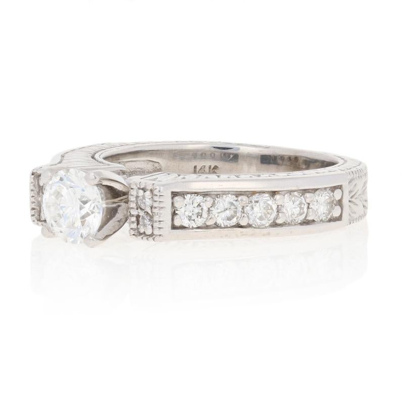 This gorgeous white gold engagement ring has a bold classic look with modern styling, and is a perfect choice for your bride-to-be!  The 14k white gold band features a center natural diamond solitaire features a timeless round cut and is set in a
