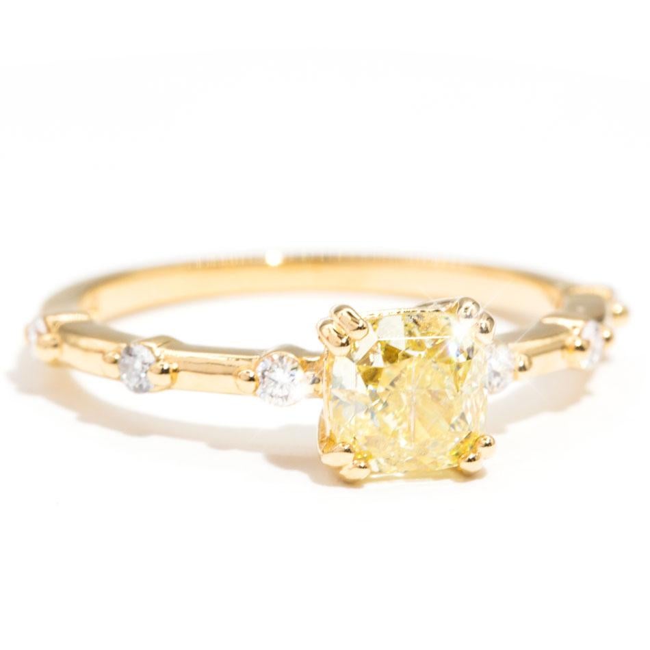 Lovingly crafted in yellow gold is this gorgeous engagement ring featuring a sparkling 1.02 carat certified fancy light yellow cut diamond. The centre diamond is set with double claws, and is flanked with six round brilliant cut diamonds that are