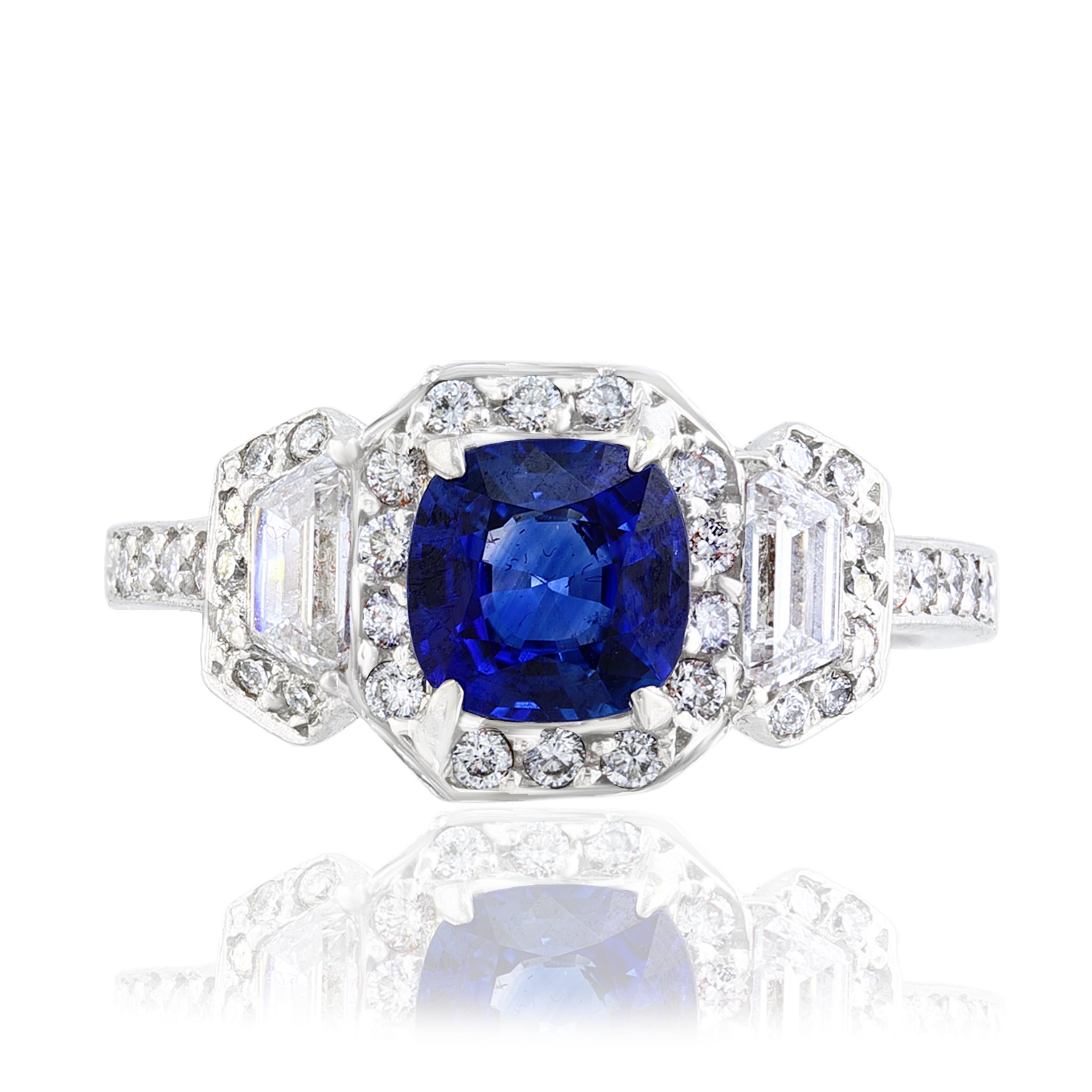 A stunning ring showcasing a rich blue cushion cut sapphire weighing 1.02 carats surrounded by a row of diamonds. Flanking the center stone are two brilliant cut straight baguette diamonds, weighing 0.28 carats total, framed in a brilliant diamond