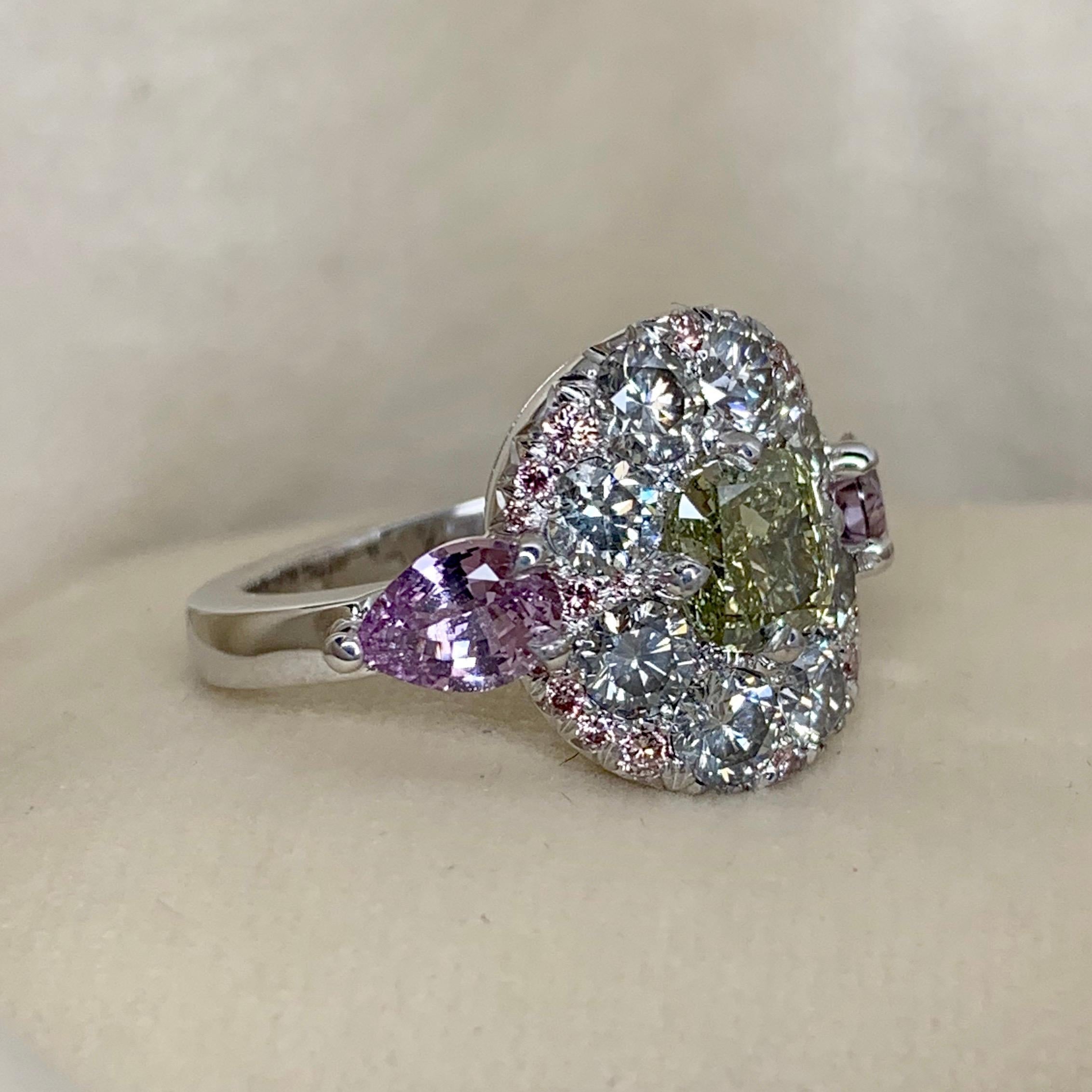 One of a kind ring in 18K White gold 10,2 g. Set with a GIA certified fancy Olive green diamond cushion centerstone 1,02 Carat ( laser inscription GIA 5181202576 ), Fancy Grey diamonds 1,50ct., Fancy Pink diamonds 0,16 ct., fancy blue diamonds 0,08