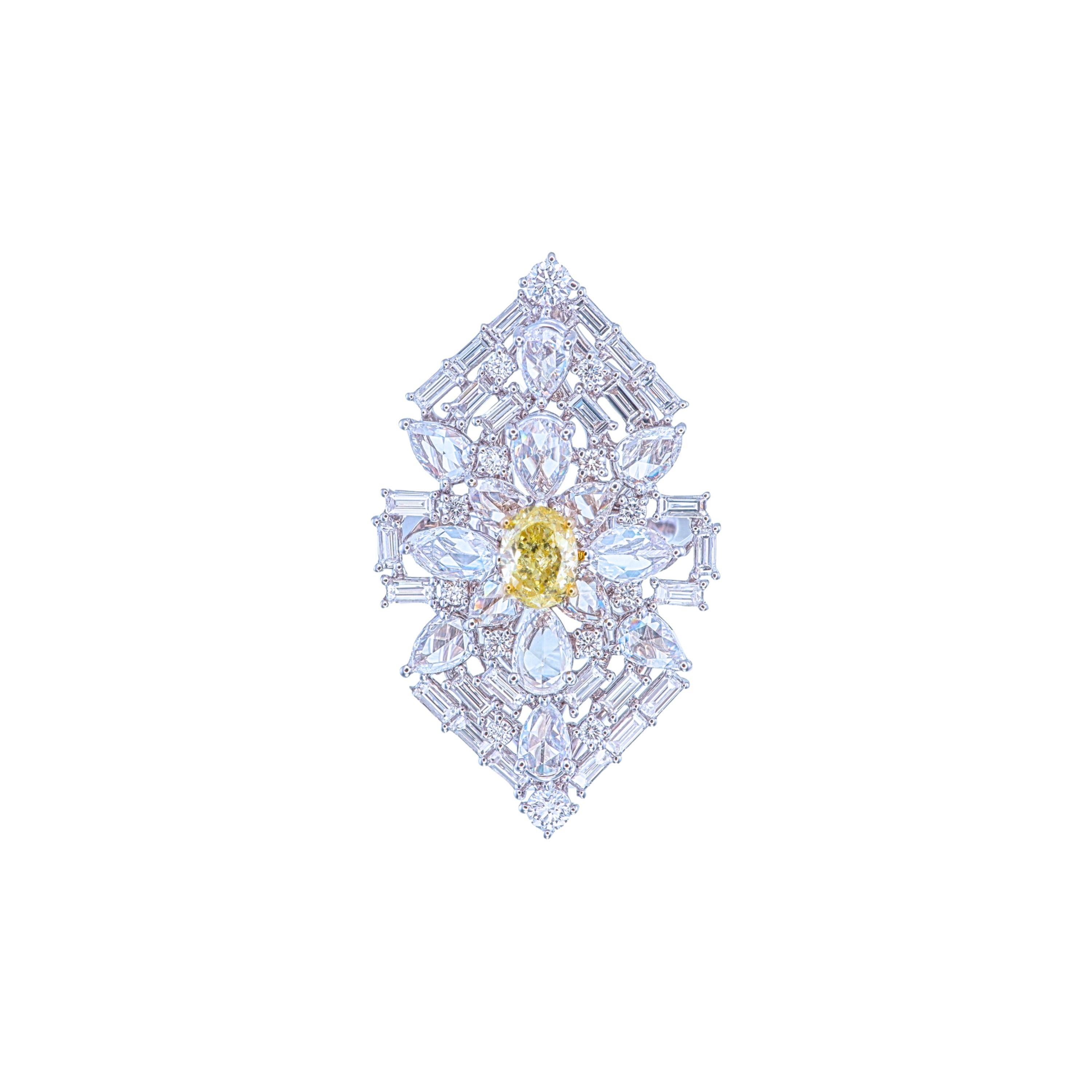 Este cautivador anillo de oro blanco de 18 quilates presenta un impresionante Diamante Oval Amarillo Fancy de 1,02 quilates en su centro, que ofrece un vivo estallido de color. La radiante pieza central se complementa maravillosamente con 4,86