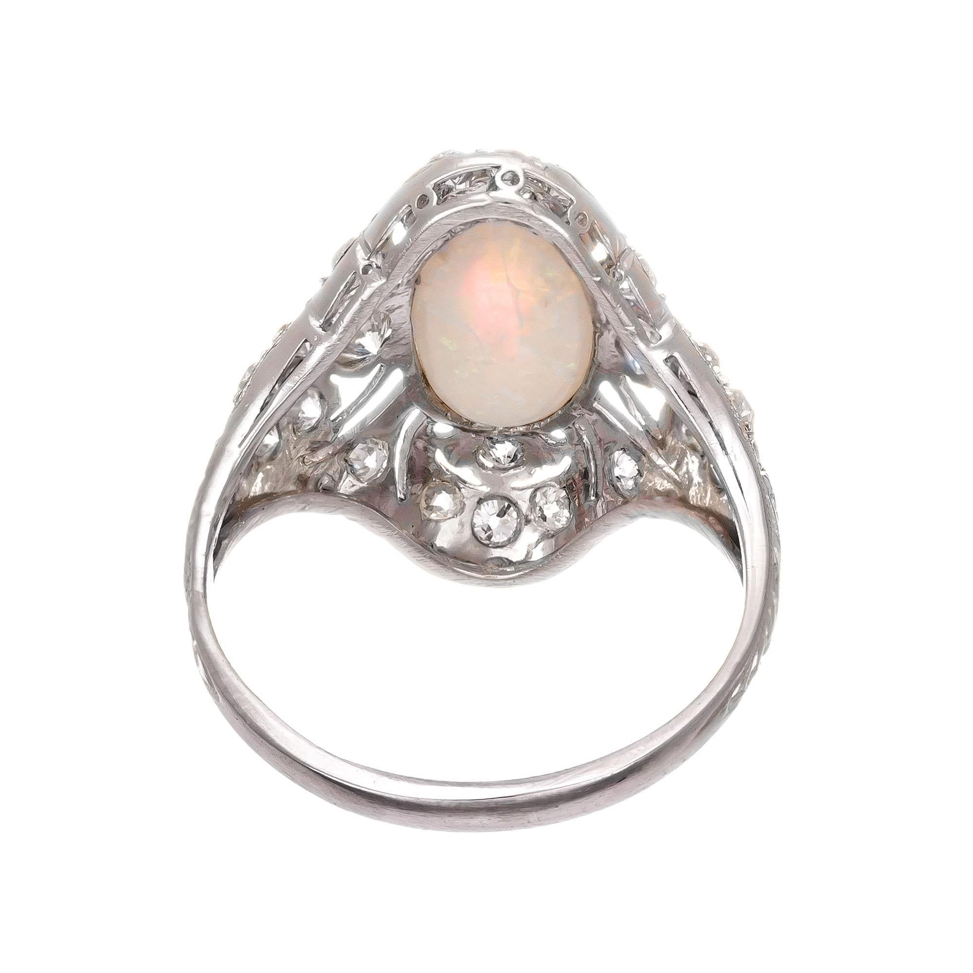 Vintage 1910 open work opal and diamond art deco platinum ring. Oval cabochon center opal with round accent diamonds in platinum.

1 oval white (green,red,blue) cabochon opal, approx.  1.02cts
22 round diamonds G-H VS-SI .46ct
Size 5.75 and sizable