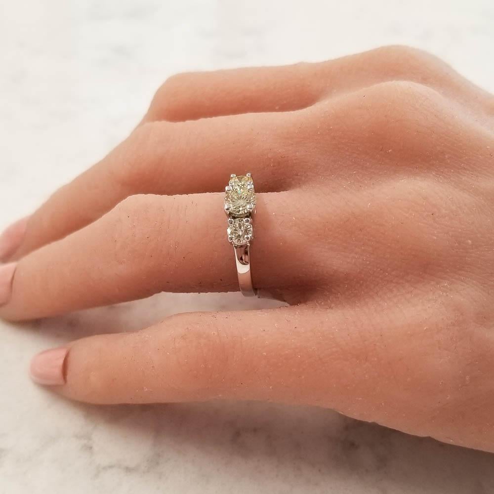 A trio of natural yellow diamonds make this ring impossible to resist! The unique warm diamond color is intriguing and radiant like glowing sunlight. The 1.02 carat total of round brilliant diamonds are set into beautifully polished 14 Karat white