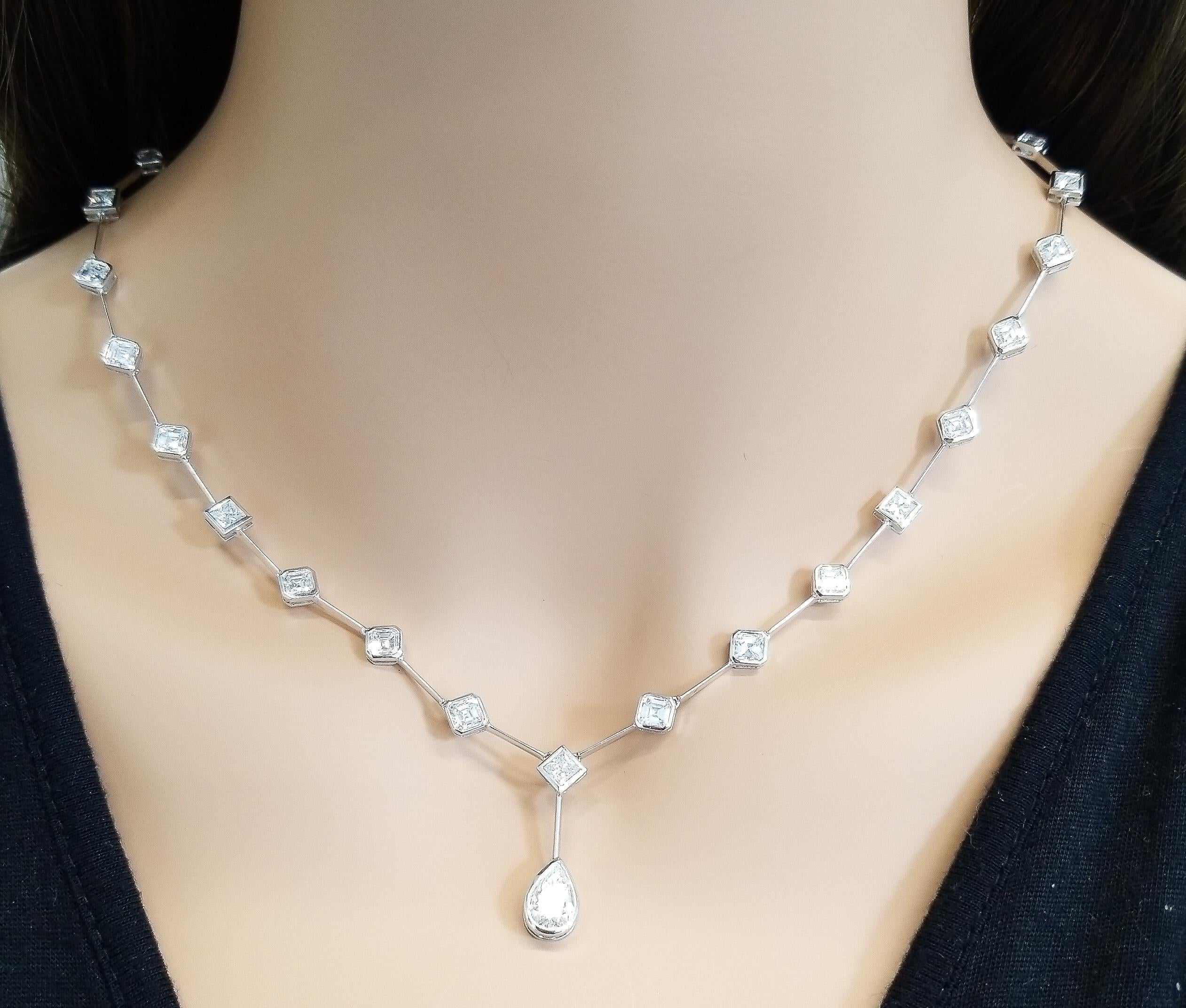 Daring geometric shapes adorn this handmade station necklace. The first aspect you’ll notice is the sparkling 1.17 carat pear shaped diamond that drops from the center. You’ll also be delighted by the 2.15 carat total princess cut diamonds, and the