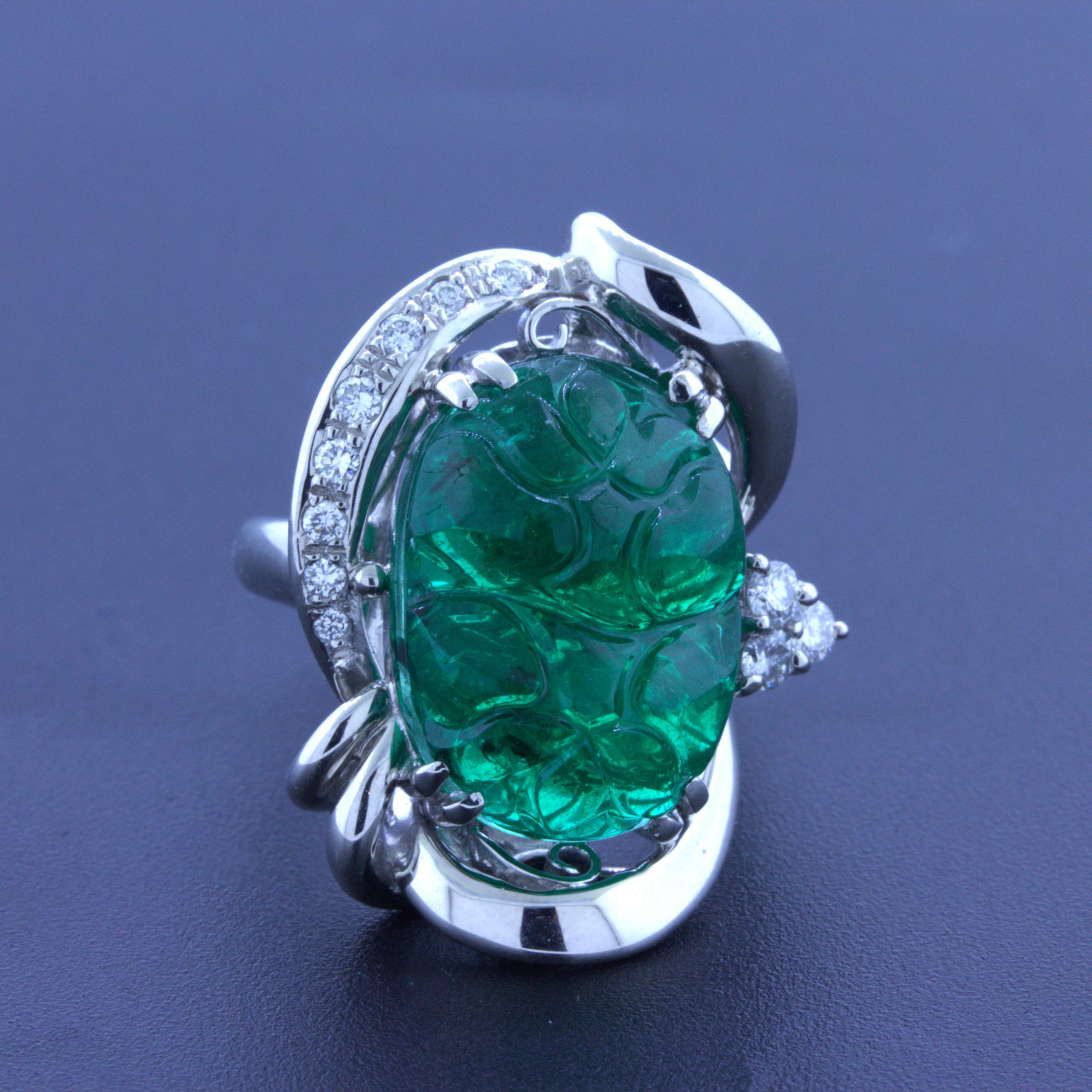 A chic and elegant platinum ring featuring a fine natural carved emerald. It weighs an impressive 10.23 carats and has a very rich, yet still bright, vivid grass green color. It has been hand-carved with floral motifs making it stand out. It is