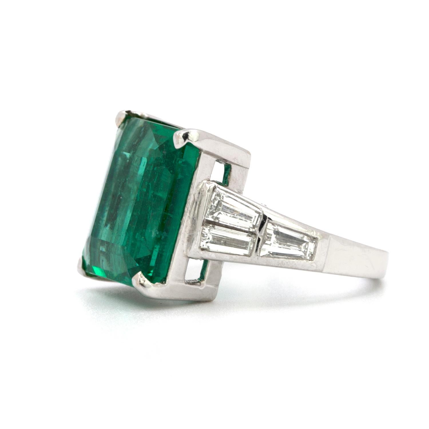 A beautifully crafted platinum ring that features a 10.23 carat Colombian colored natural emerald is set with 6 clean white tapered baguette diamonds that weigh in total 1.50 carats.    Size 6 1/4
 
