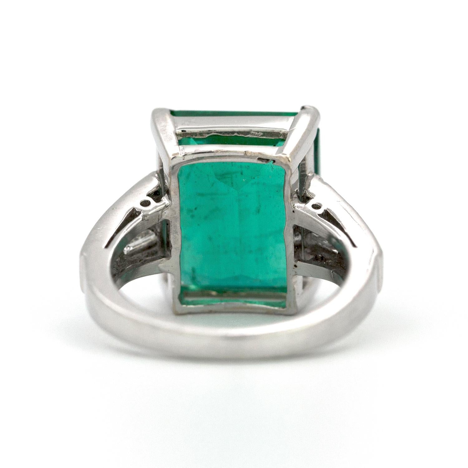 A beautifully crafted platinum ring that features a 10.23 carat Colombian colored natural emerald, set with 6 clean white tapered baguette diamonds that weigh in total 1.50 carats.      