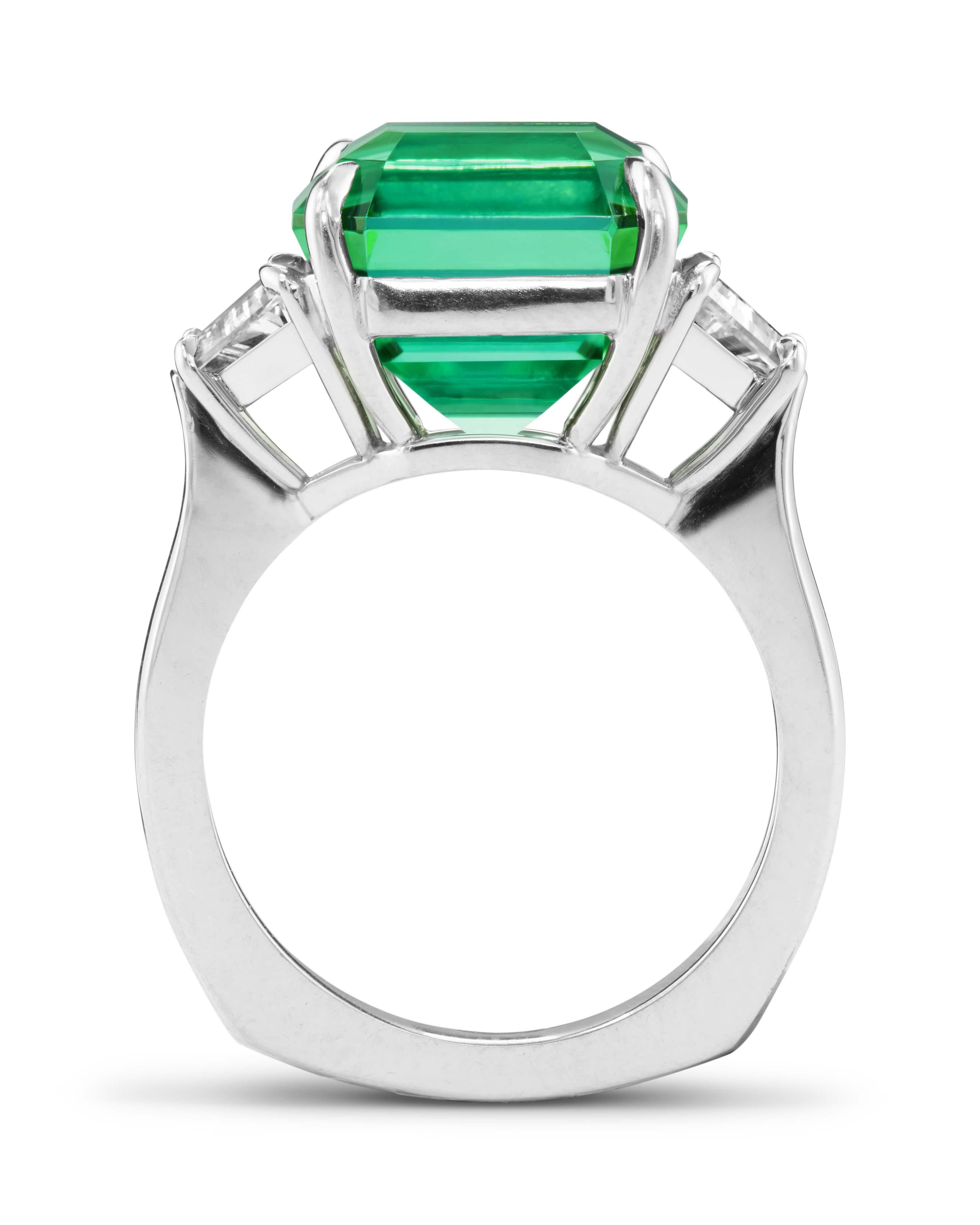 From our One-of-a-Kind collection, the main stone is a 10.23 ct. asscher-cut vibrant mint green Tourmaline. It is flanked by two trapeze-cut diamonds (0.50 ct. E SI1 and 0.41 ct. E SI1). All stones are GIA certified. The ring is handcrafted in