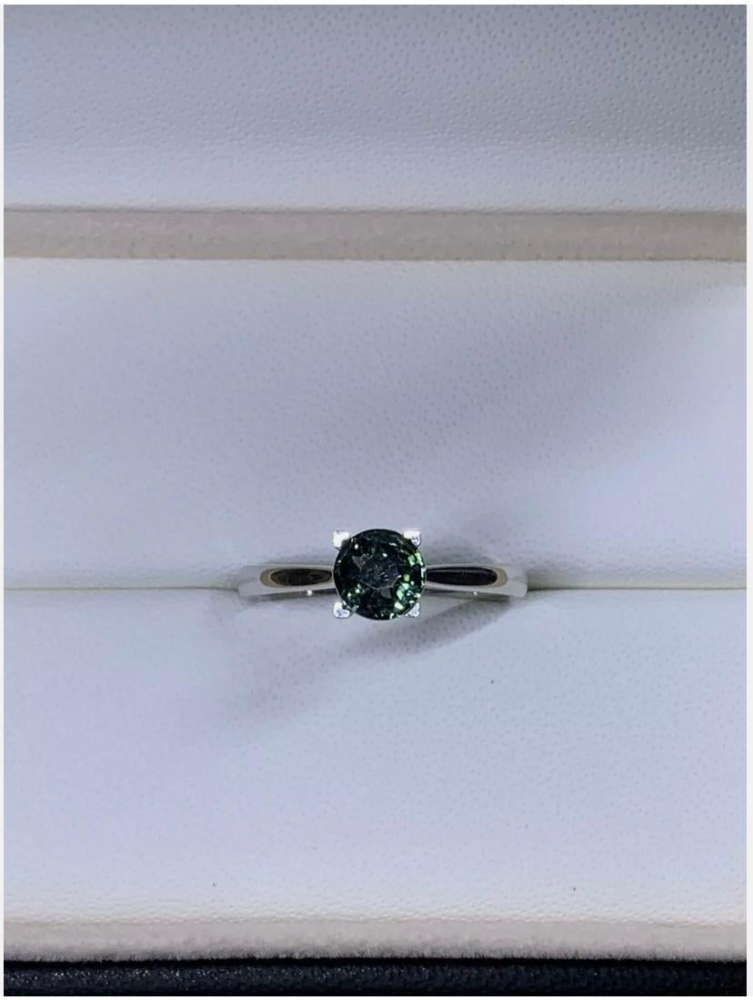 1.02ct Teal Sapphire Solitaire Engagement Ring 18ct White Gold
This stunning engagement ring features a 1.02ct round teal sapphire set in 18ct white gold. The solitaire setting style showcases the natural beauty of the gemstone. The ring is size M