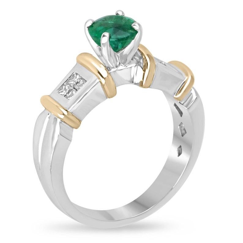 Celebrate your love with our emerald and diamond accent engagement ring, featuring a lush green round cut emerald at its center, prong set for maximum brilliance. The emerald is beautifully accented by princess cut diamond clusters on each side,
