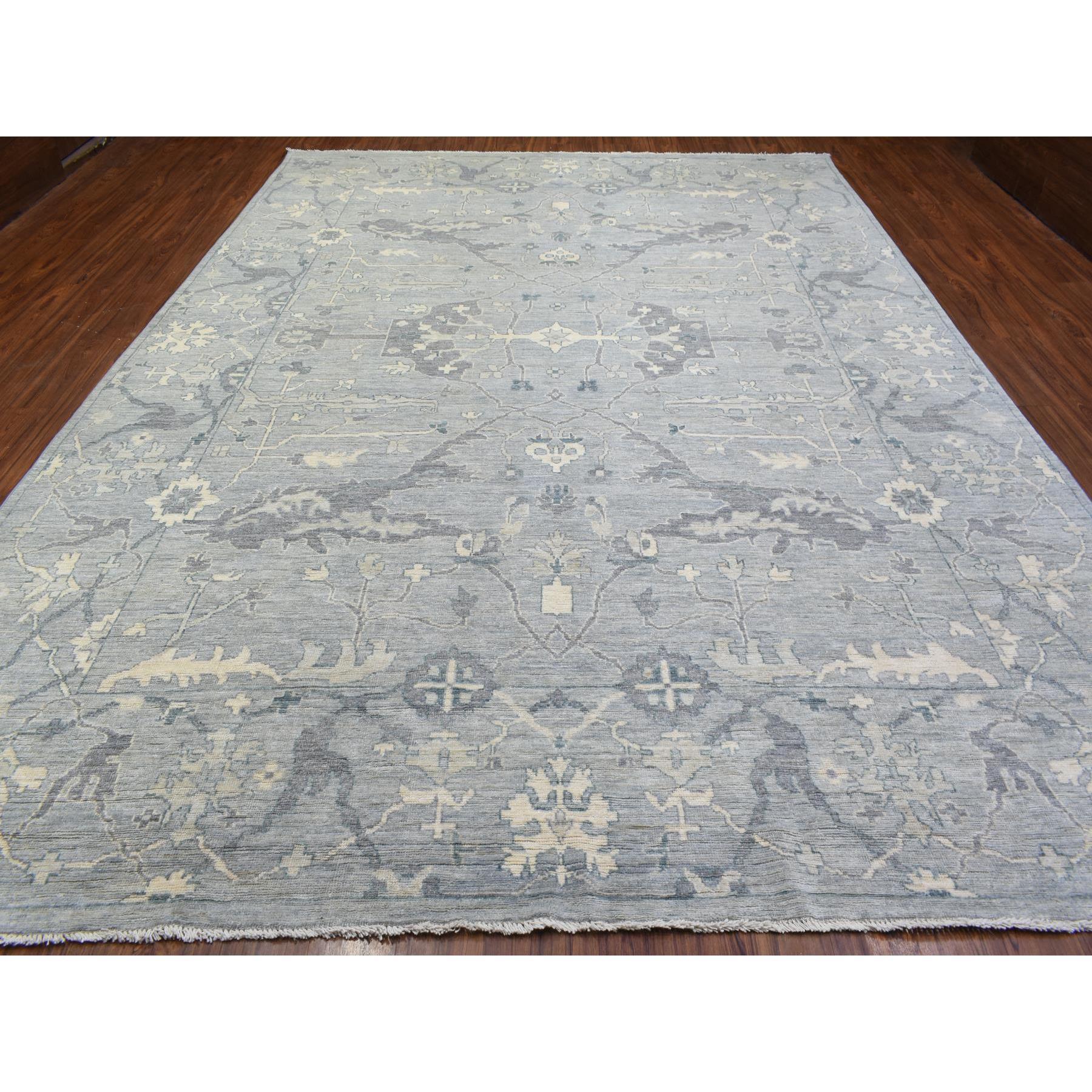 Il s'agit d'un véritable tapis d'Orient en laine grise afghane Oushak à motif ouvert et fluide, noué à la main, unique en son genre. Il a été noué pendant des mois et des mois selon des techniques de tissage séculaires par des artisans
