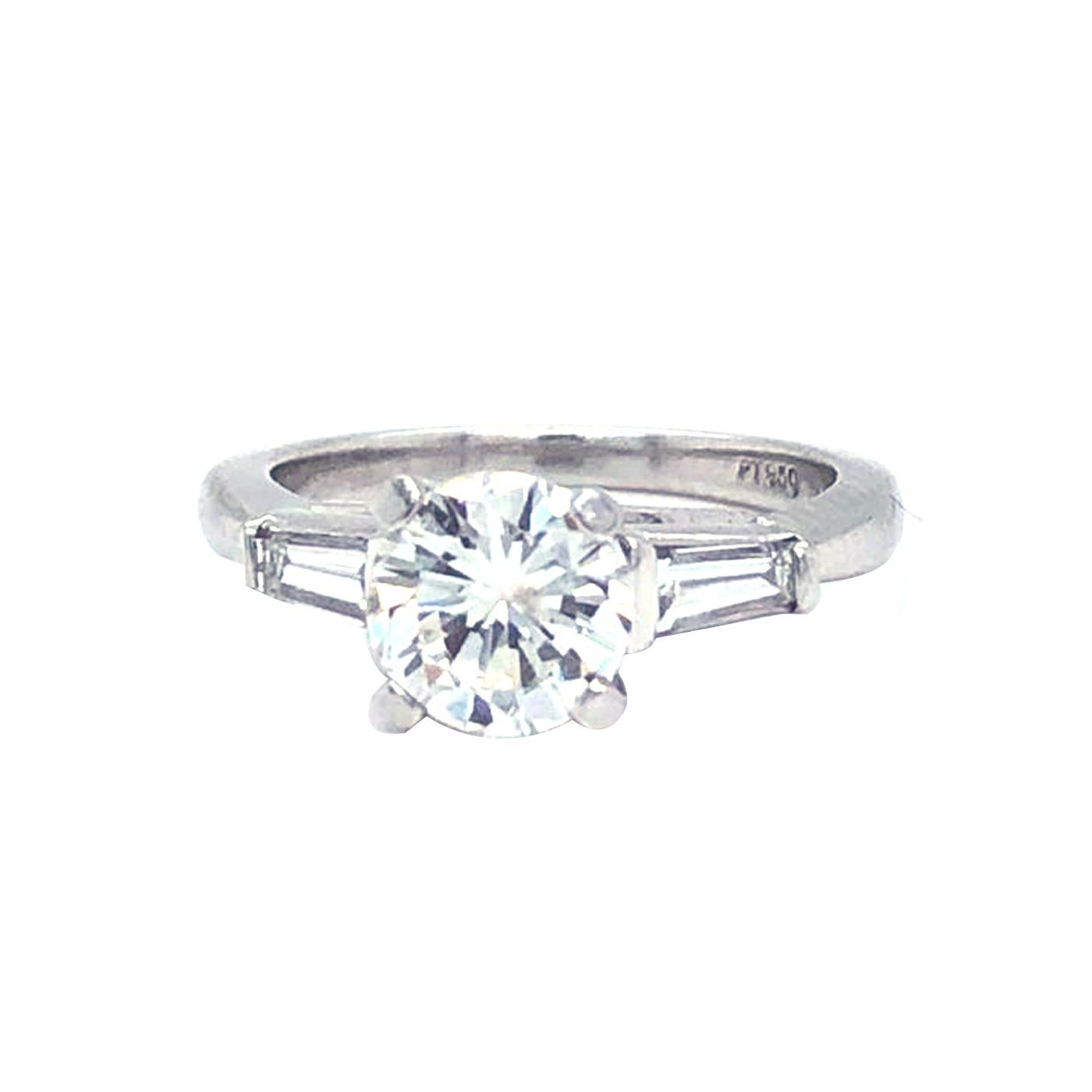 Classic Platinum Diamond ring 1.03 Carat center Round Brilliant  H - Color, Si2  Clarity, and accented by two tapered baguette-cut diamonds, Totaling 0.35 carat H color, VS1 - Clarity, The ring weighs 3.2 grams, and is currently size 6, with easy
