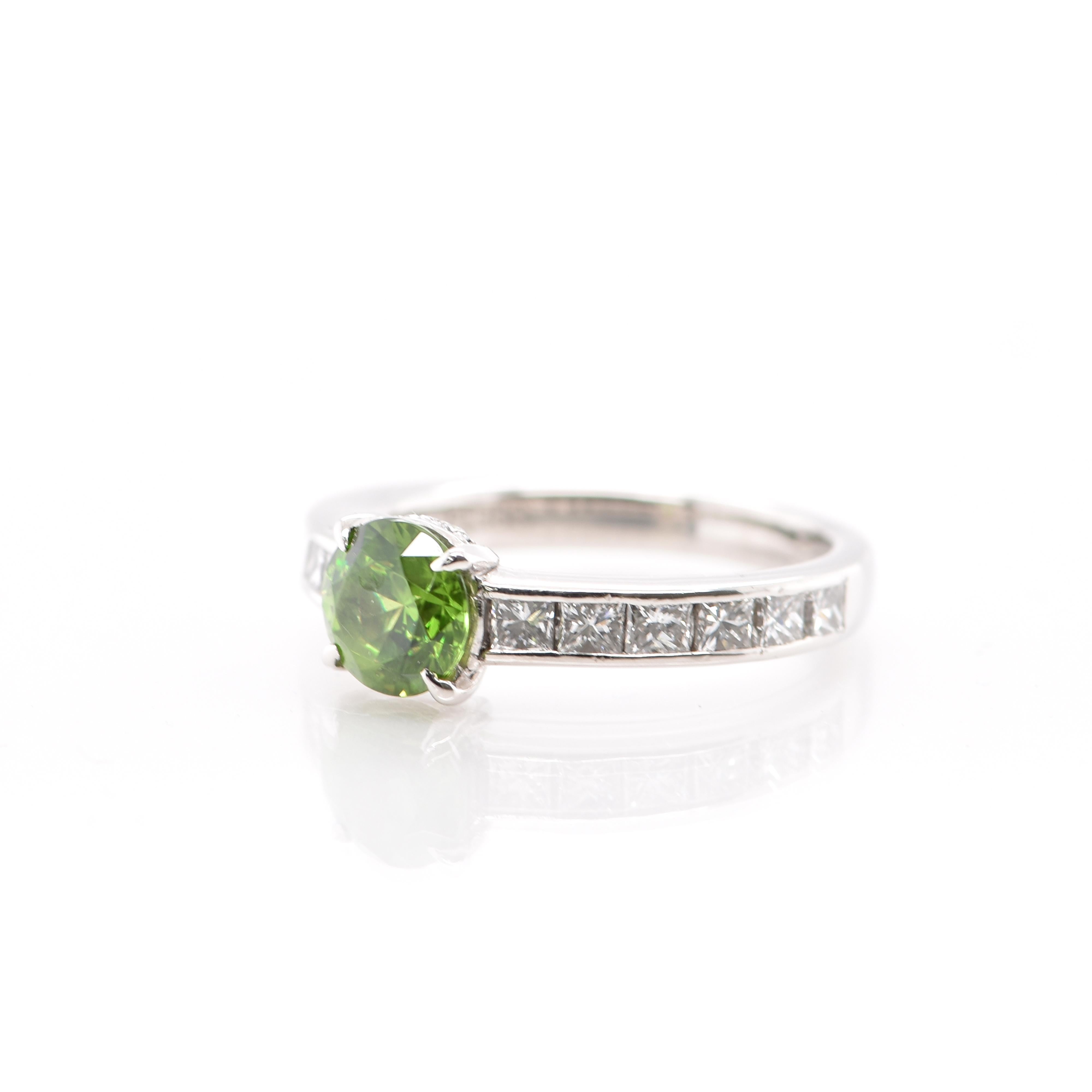 A beautiful Engagement Ring featuring a 1.03 Carat Demantoid Garnet with Horsetail feature and 0.78 Carats of Diamond Accents set in Platinum. Demantoid Garnet's only known source used to be the Ural Mountains in Russia however recent discoveries in