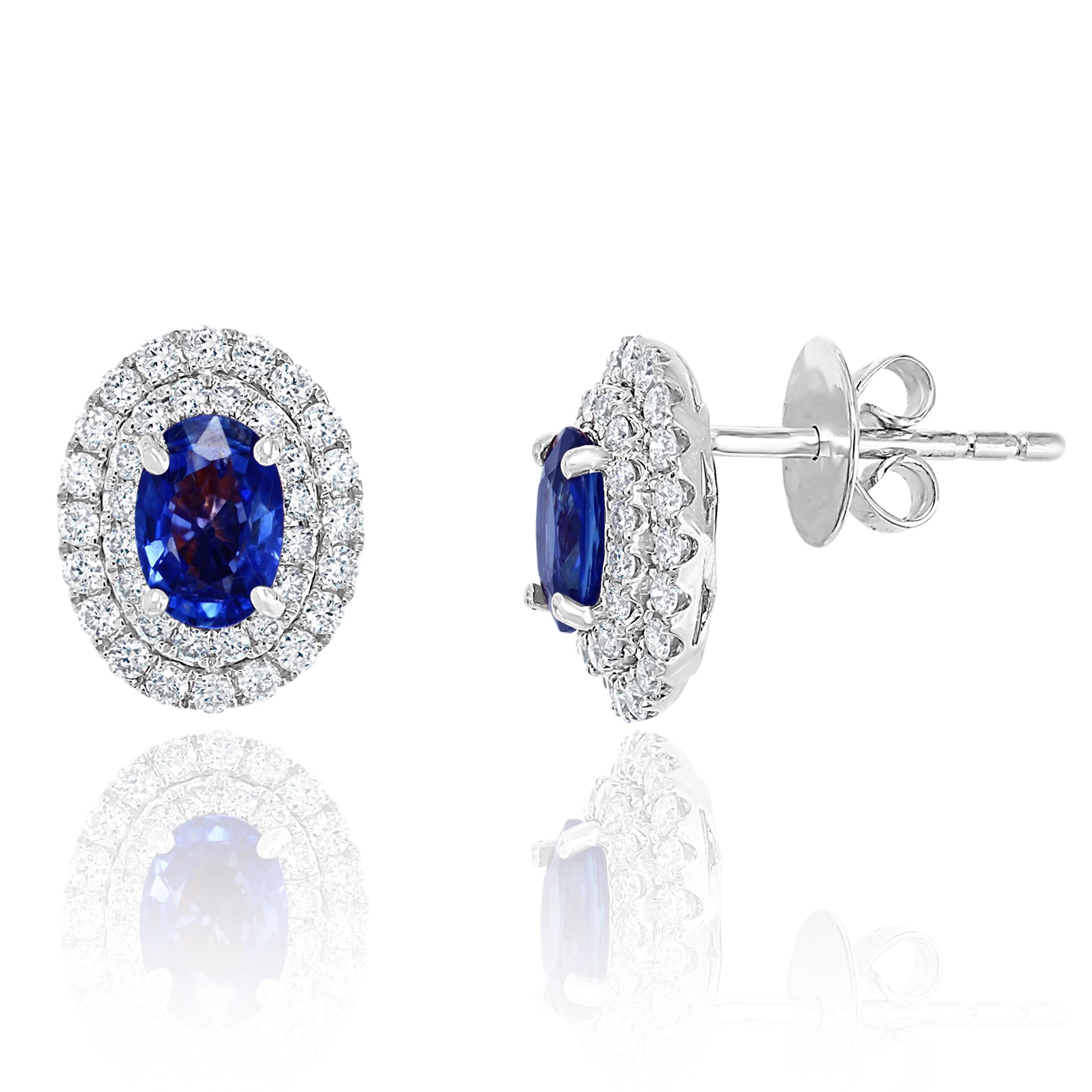 A simple pair of stud earrings showcasing 1.03 carats of oval cut blue sapphires, surrounded by a double row of 72 round brilliant diamonds weighing 0.48 carat. Made in 18 karats white gold.  