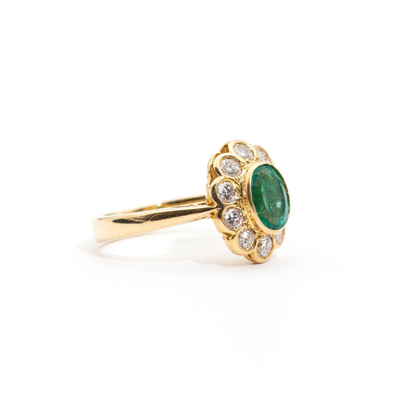 This wondrous vintage ring is forged in 18 carat yellow gold and features a stunning bright 1.03ct faceted oval emerald and is surrounded by a perfect border of ten round brilliant cut diamonds. We call this ever so charming piece The Juniper Ring. 