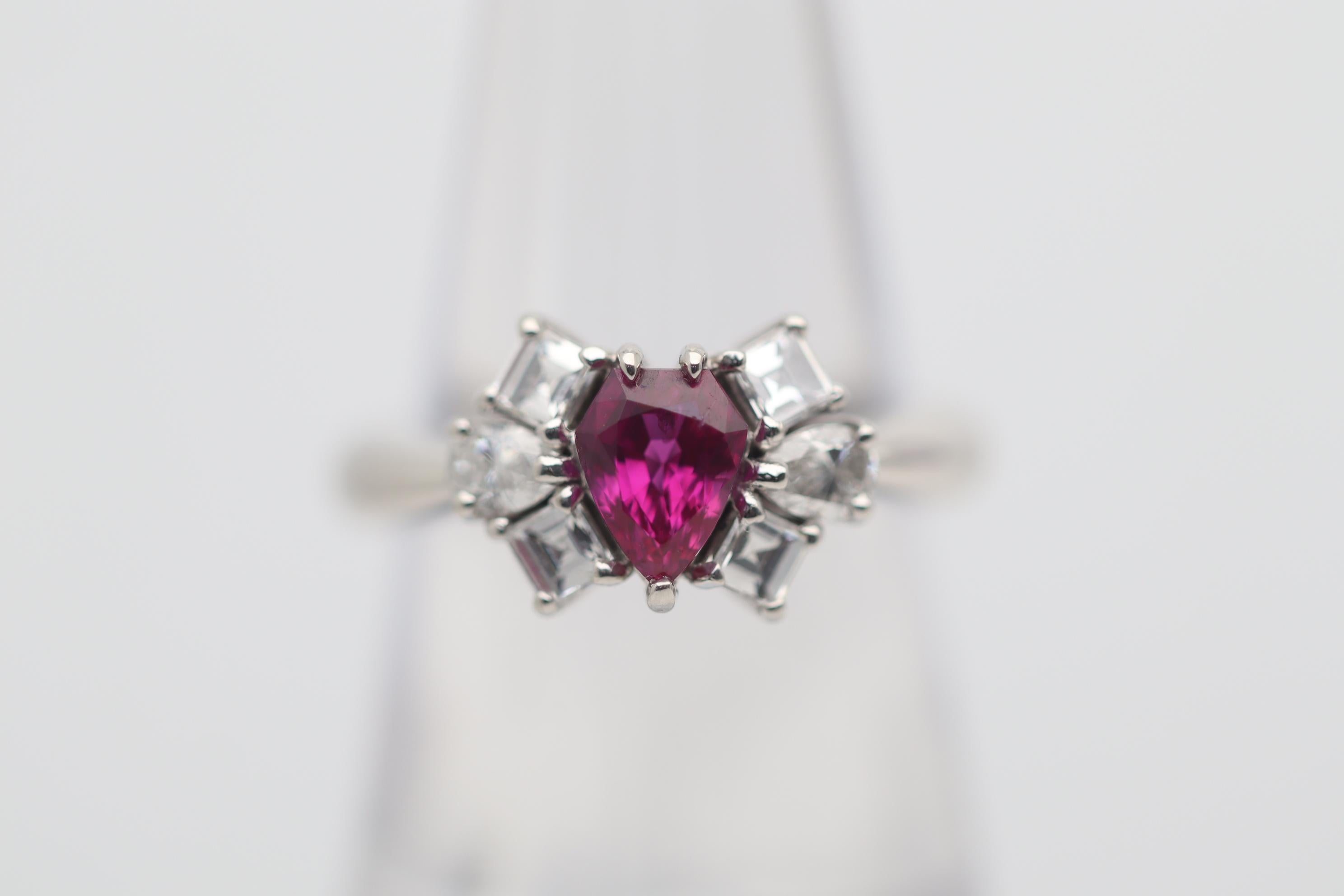 A stylish and chic ring featuring a 1.03 carat ruby with a unique shield-cut. The ruby has a bright and brilliant slightly pinkish-red color which is full of light and sparkle. The shield-cut is rarely used for rubies and other fine colored stones