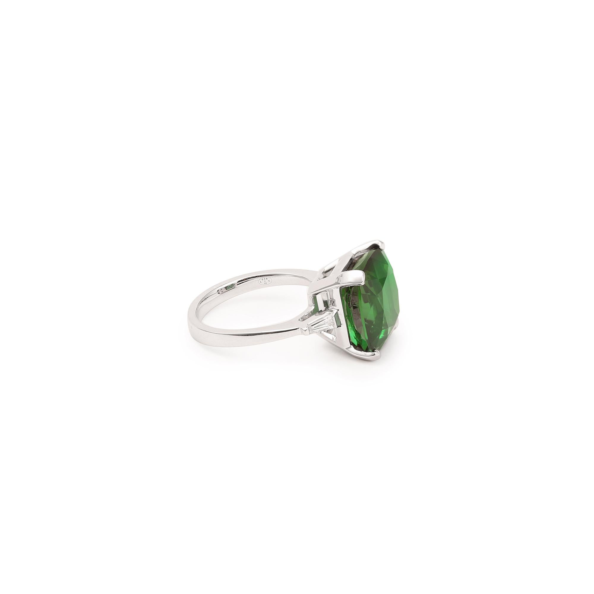 White gold ring set with a superb cushion-cut green tourmaline and a trapeze-cut diamond on each side.

Weight of the tourmaline : 10.33 carats

Dimensions: 13.04 x 13.04 x 10.35 mm (0.514 x 0.514 x 0.408 inch)

Finger size: 53 (US size: 6.5)

18K