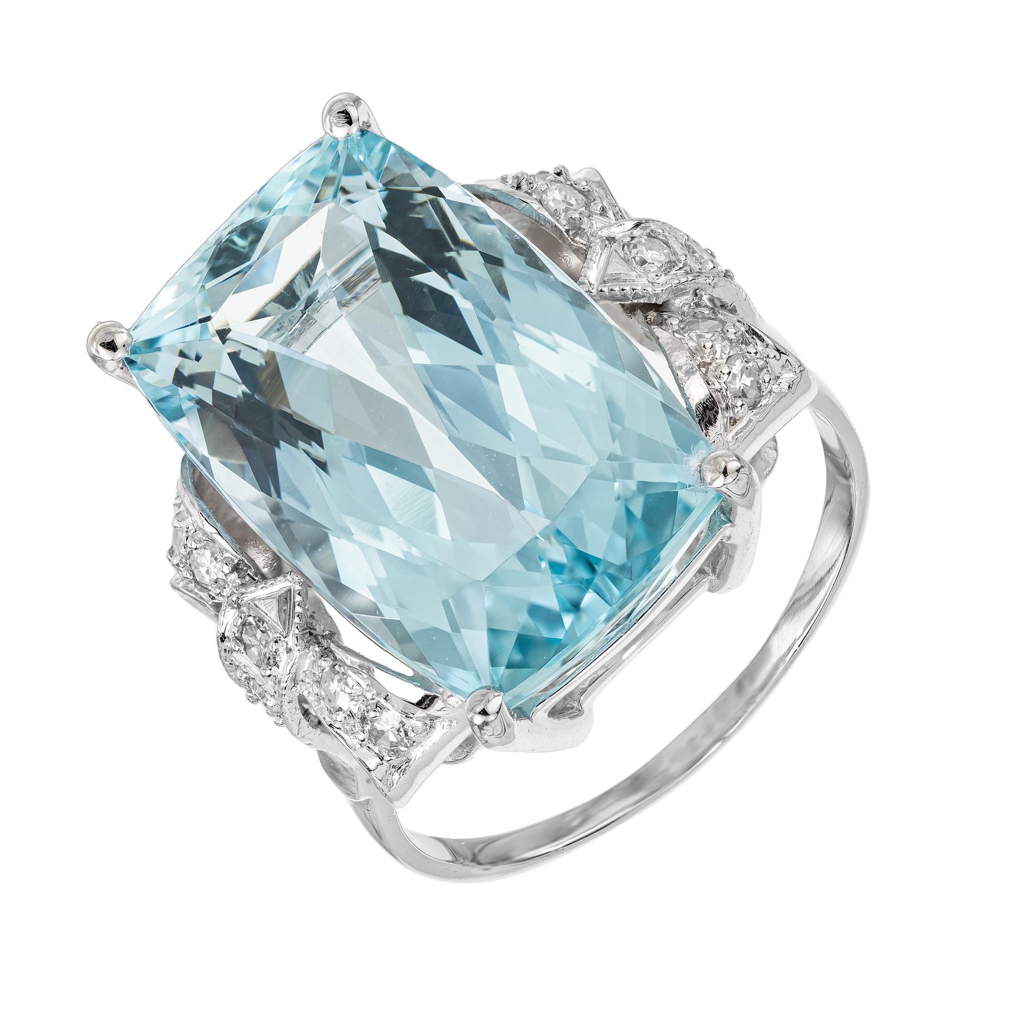This exquisite 1940's ring features a mesmerizing 10.35 carat cushion cut aquamarine center stone. Mounted in a platinum bow style setting which is accented with 18 single cut diamonds. The aqua is a rich bright pale blue. The ring is a stunning