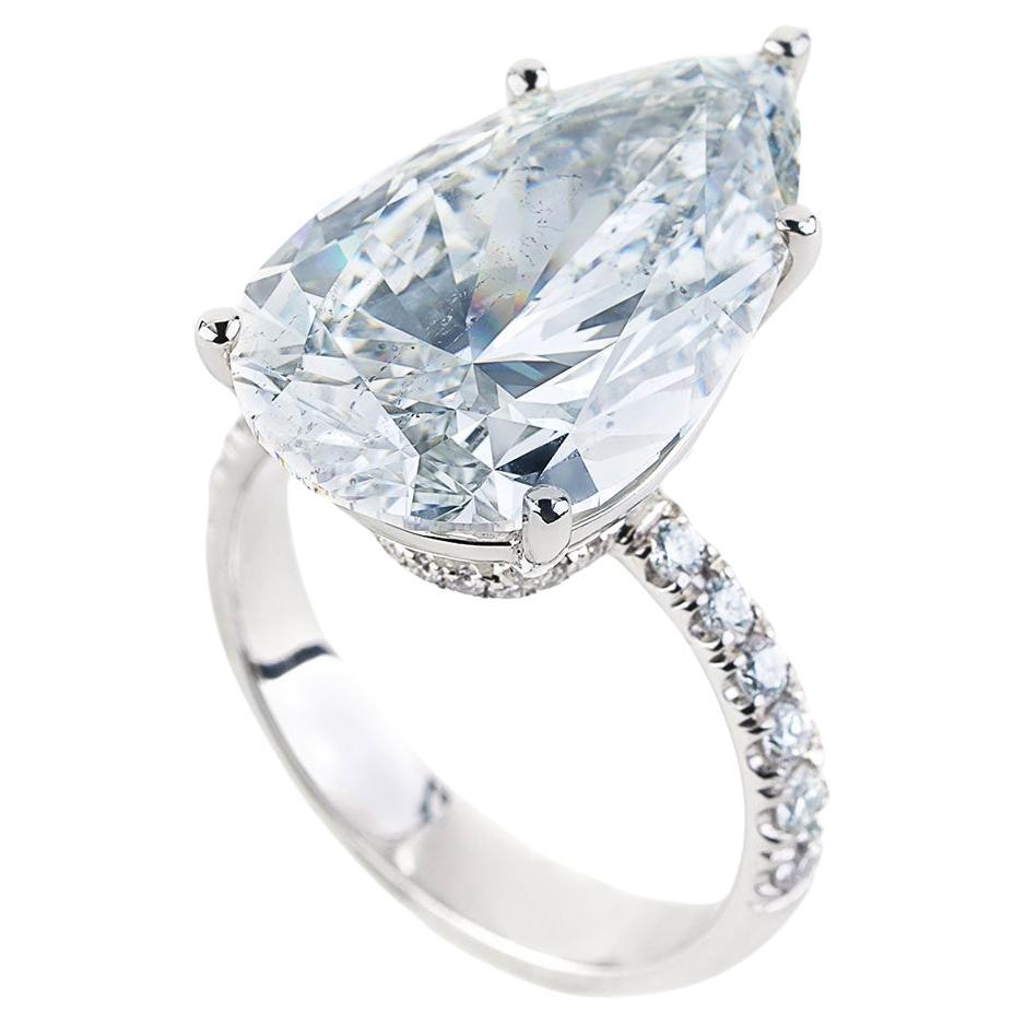 This exquisite engagement ring features a dazzling 10.35-carat, H-color, SI2-clarity, pear-cut diamond as its stunning centerpiece. Accompanied by a GIA report, the diamond is meticulously showcased and complemented by 32 round diamonds weighing a