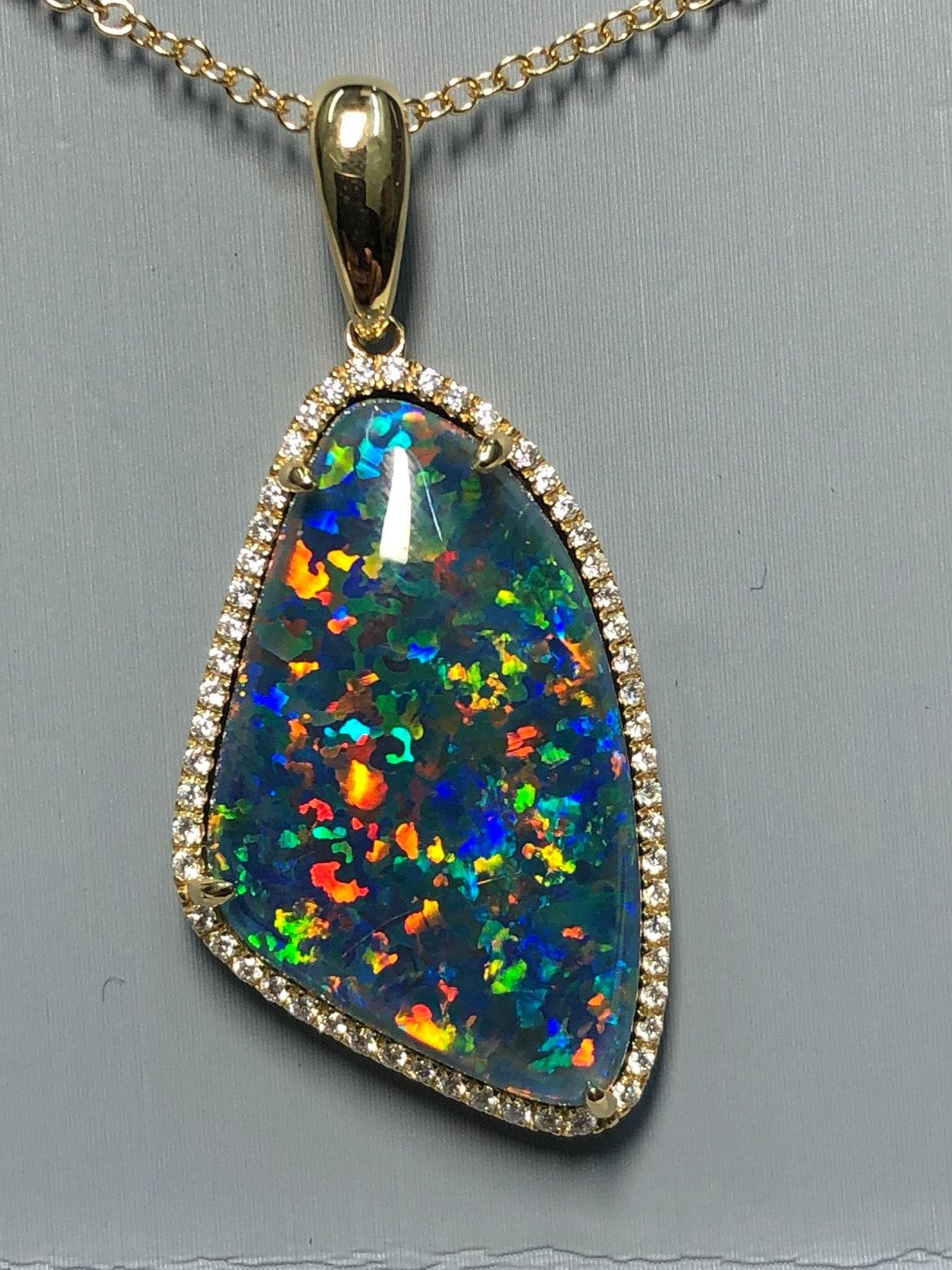 10.36 Carat Australian Opal Diamond Necklace  18 karat Yellow Gold . This shows off bright colors Blue Yellow Green Orange Red  which is a rare color as its so hard to find in them . The black opals found in Coober Pedy is considered some of the